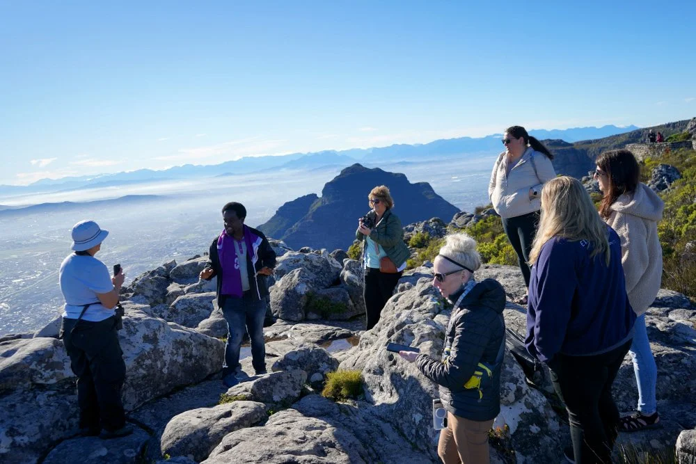 Our G-Adventures Guide Shadwell explains the local lore around Table Mountain to the Travel With Anne group on top of the mountain
