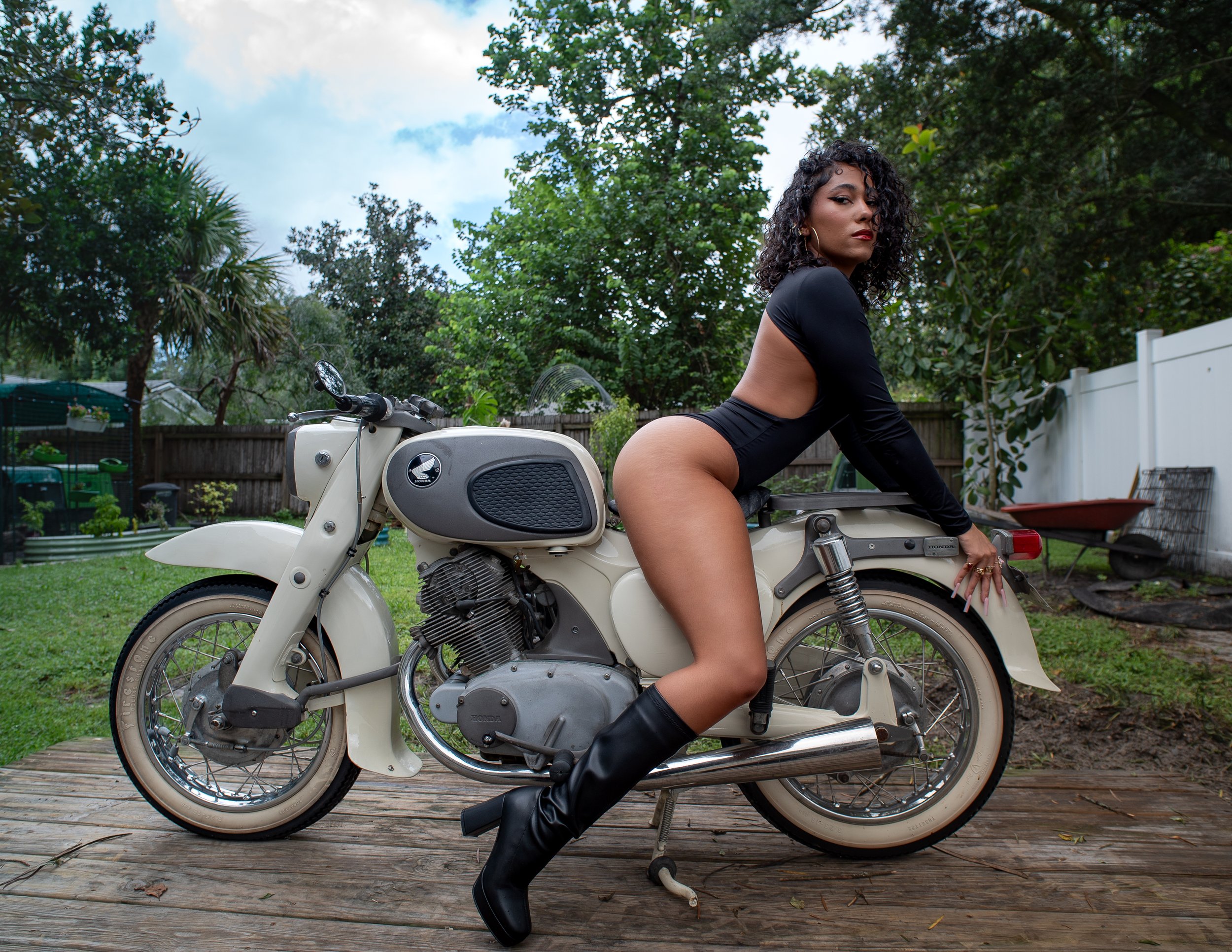 Sio on the back of a 1965 Honda Dream 305 motorcycle