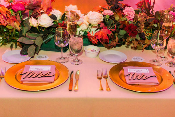 Mr and Mrs place settings and flowers at the head table