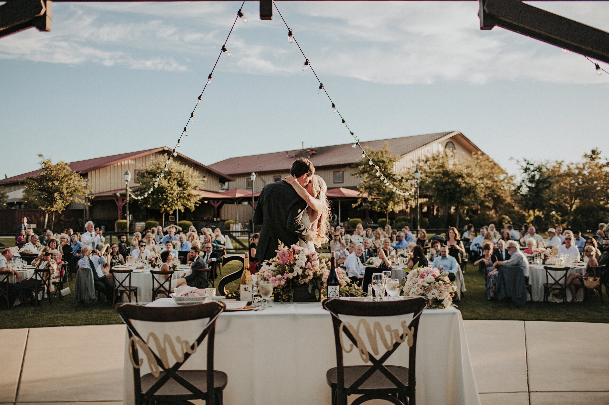 Bride &amp; groom kissing in front of head table in Mountain View venue