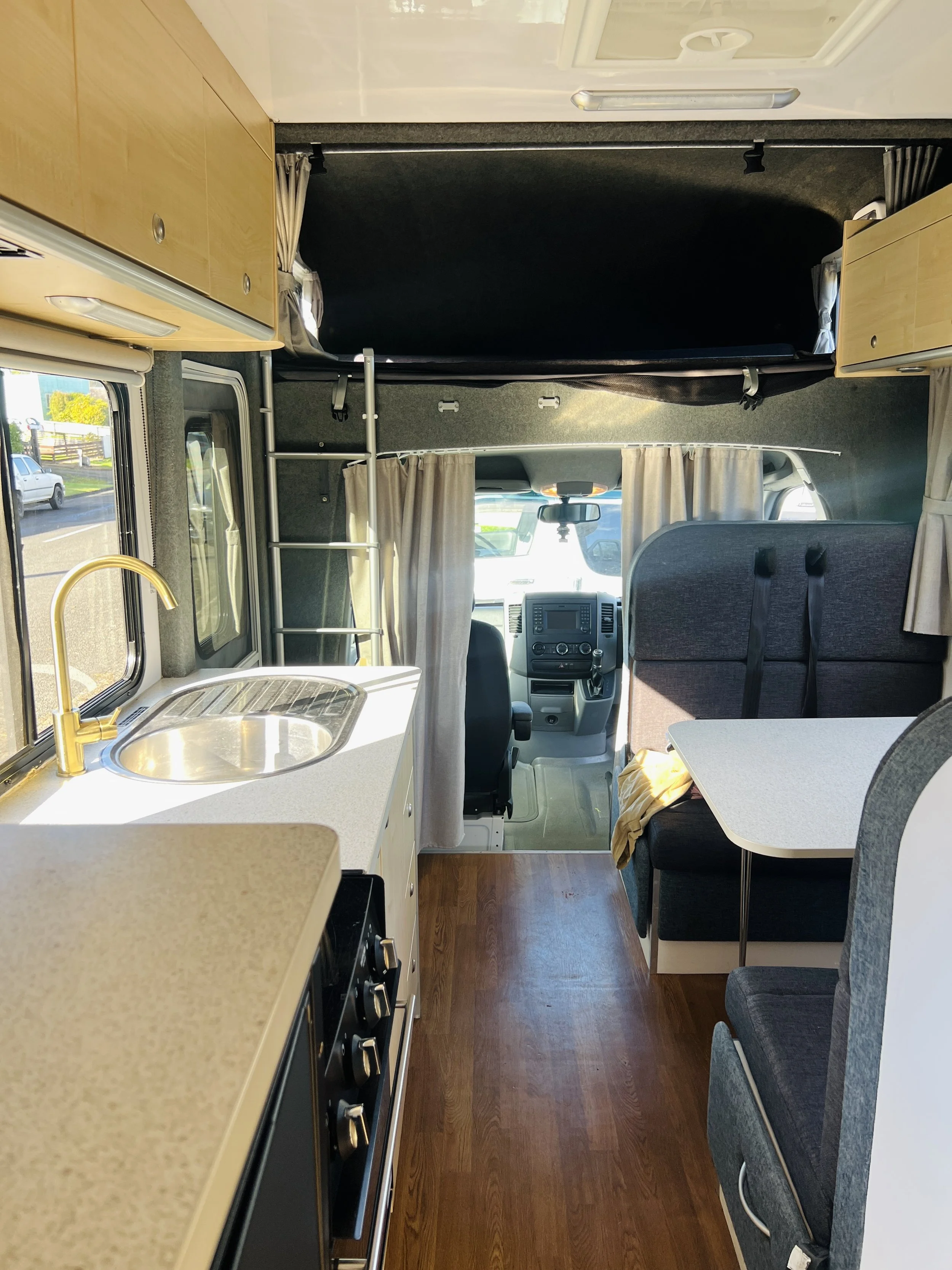 Interior of the Mojo Campers Leo 6 berth motorhome looking through the galley kitchen towards the driver's cab