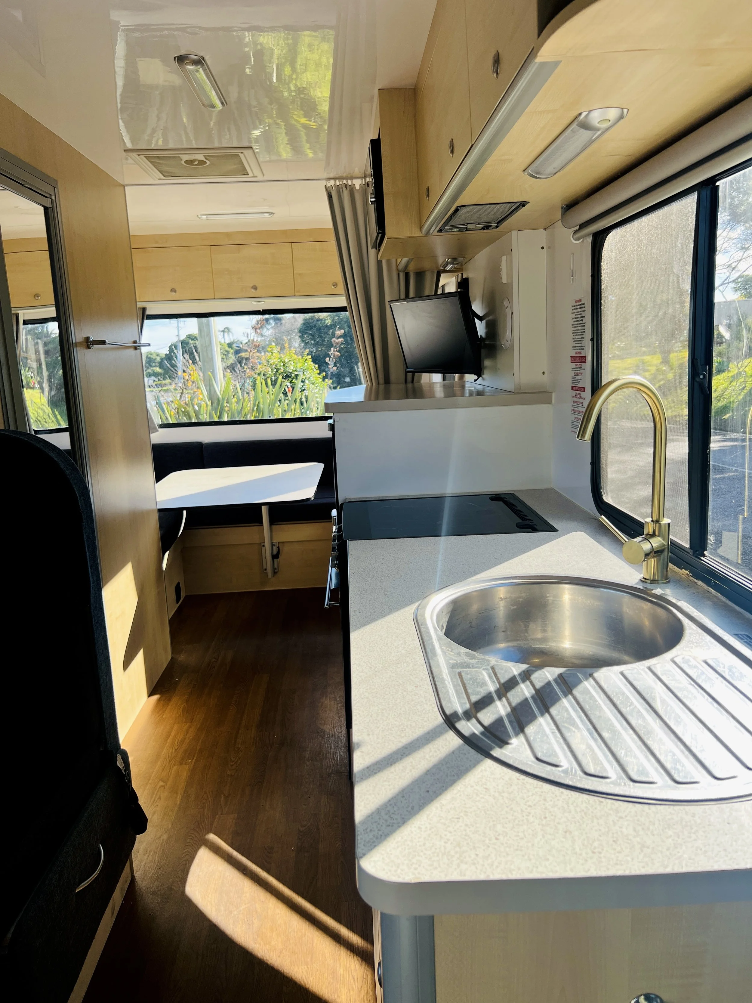 Motorhome kitchen with gas cooktop, sink and bench space in the Mojo Campers Leo, New Zealand