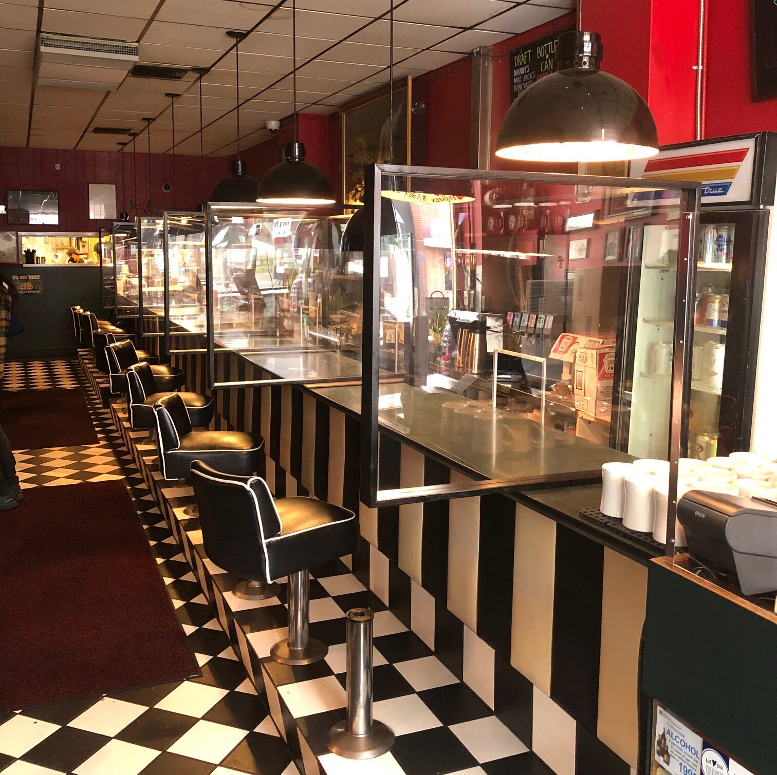 The diner counter at the Mecca Cafe showing plexiglass partitions between customers, and between customers and staff.