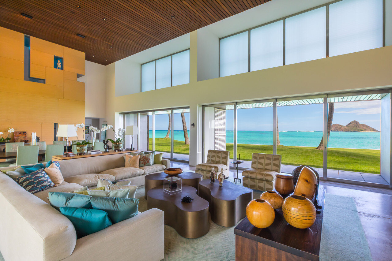    The double-height living space features sliding glass walls that  disappear into a pocket to allow for indoor-outdoor living. Pamela  Banker Associates designed the interiors; all of the furniture is custom  made to fit the scale of the home. The 