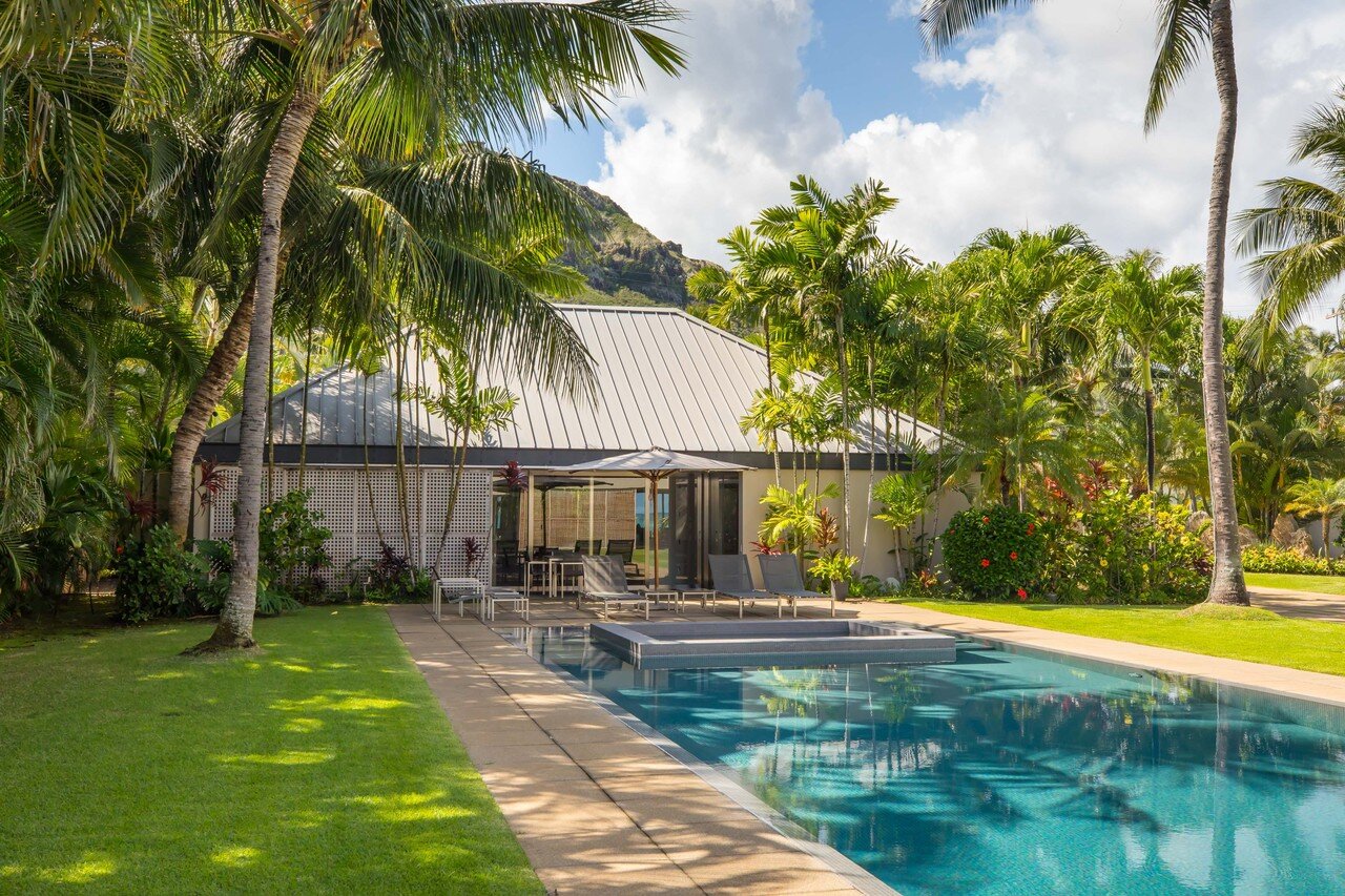  The pool is designed with a shallow “beach” area near the integrated  spa. The landscape is planted with native vegetation and coconut palms.  Hiep Nguyen/Slick Pixels Hawaii 