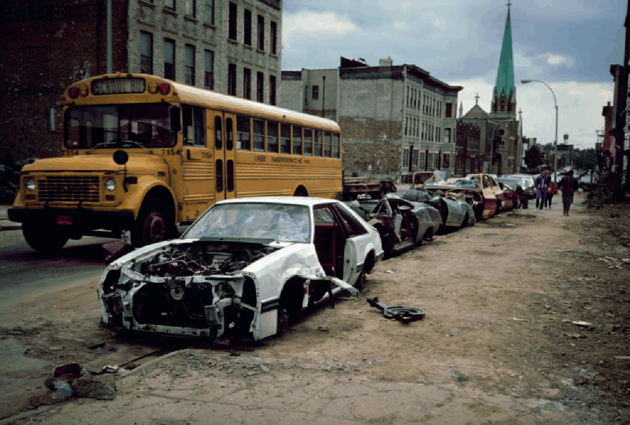 Meryl-Meisler-School-Bus-and-Curbside-Crushed-Cars-Palmetto-St.-Bushwick-Brooklyn-NY.-May-1985-1024x690.png