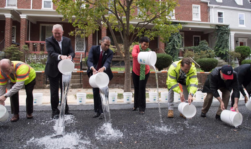 DC officials celebrate the groundbreaking of a green infrastructure project financed by an Environmental Impact Bond.