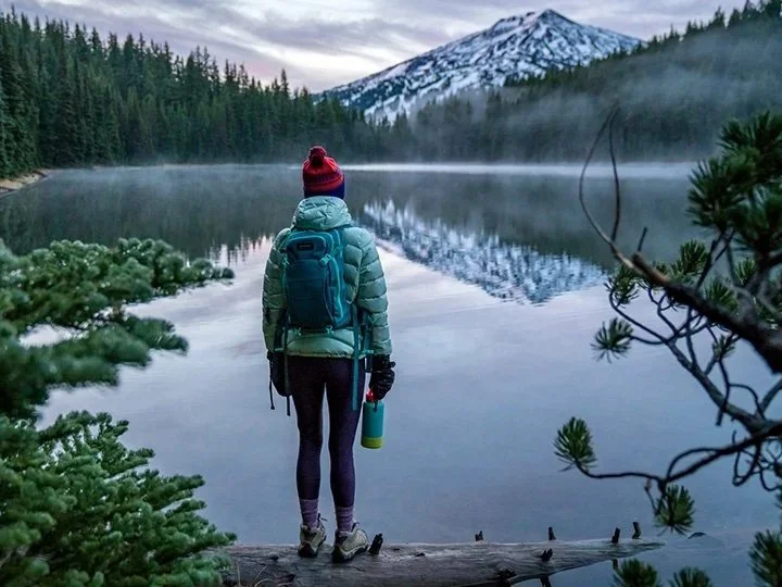A female hiker at Todd Lake in Deschutes National Forest with Mount Bachelor in the background