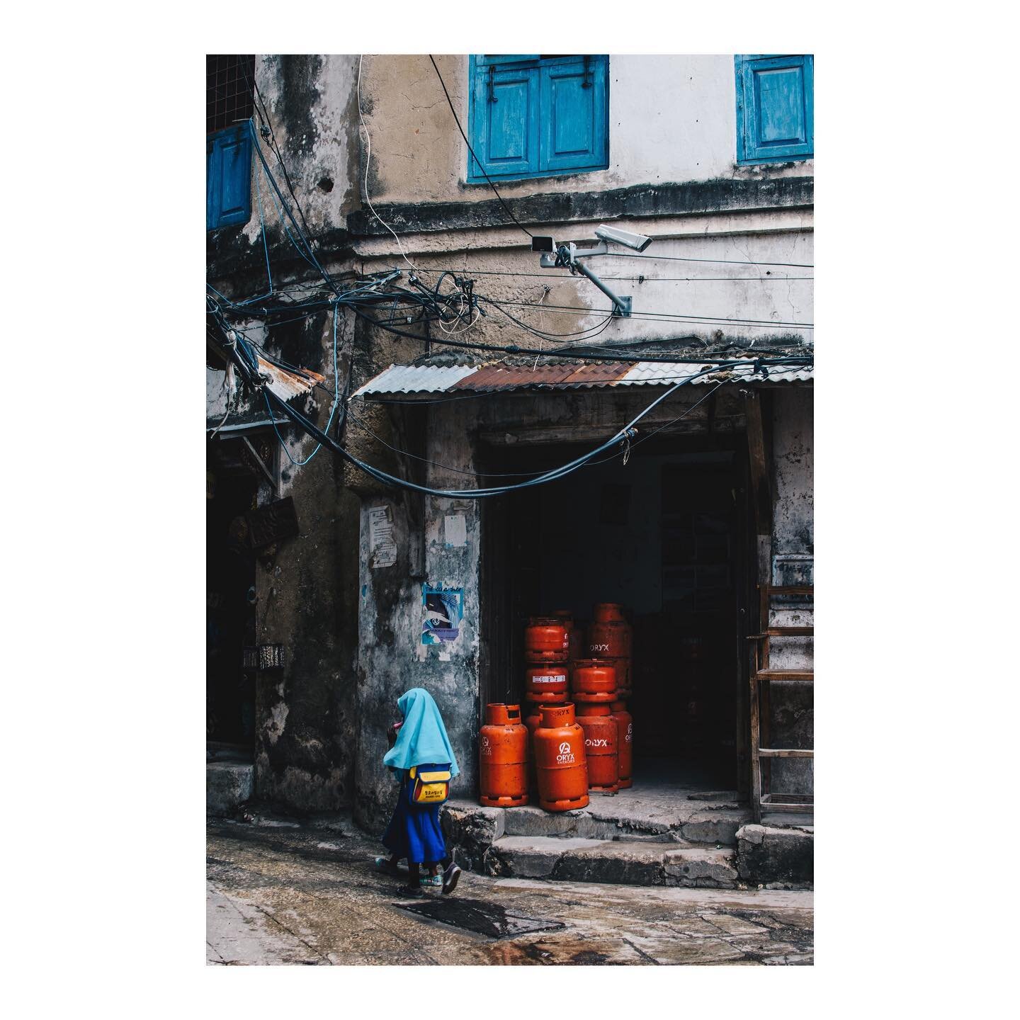 A young girl walks home from school  through the alleyways of Stone Town, Zanzibar. 

#dsdocumentary #zanzibar 
.

.
.
.
.
.
.
#stonetown #nikon #nikonphotography #nikonnz #nikond750 #nzdphoto #nzdphoto_magazine #progearfeature #photographer #photojo