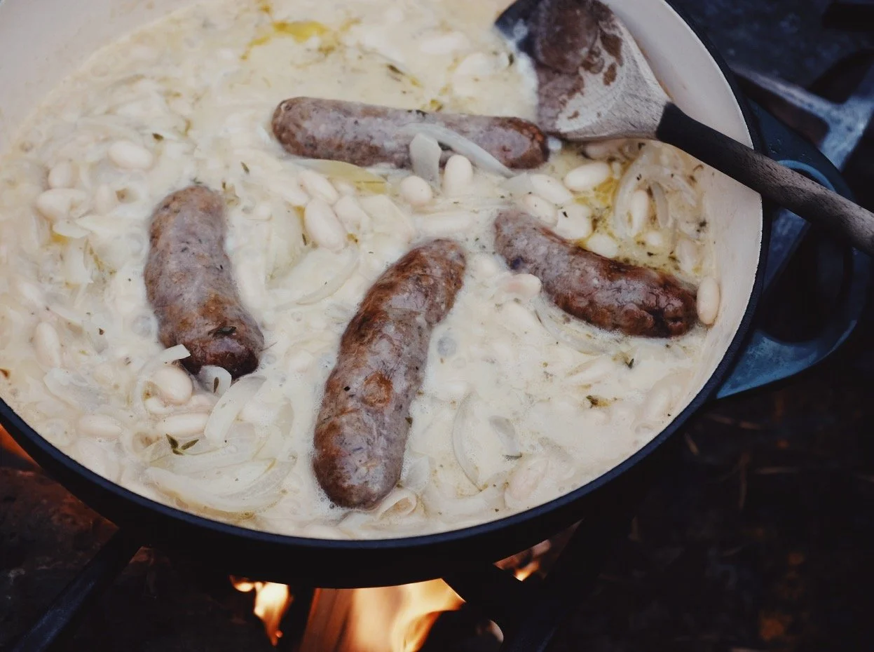 Venison sausages and white beans with cider, cream and mustard