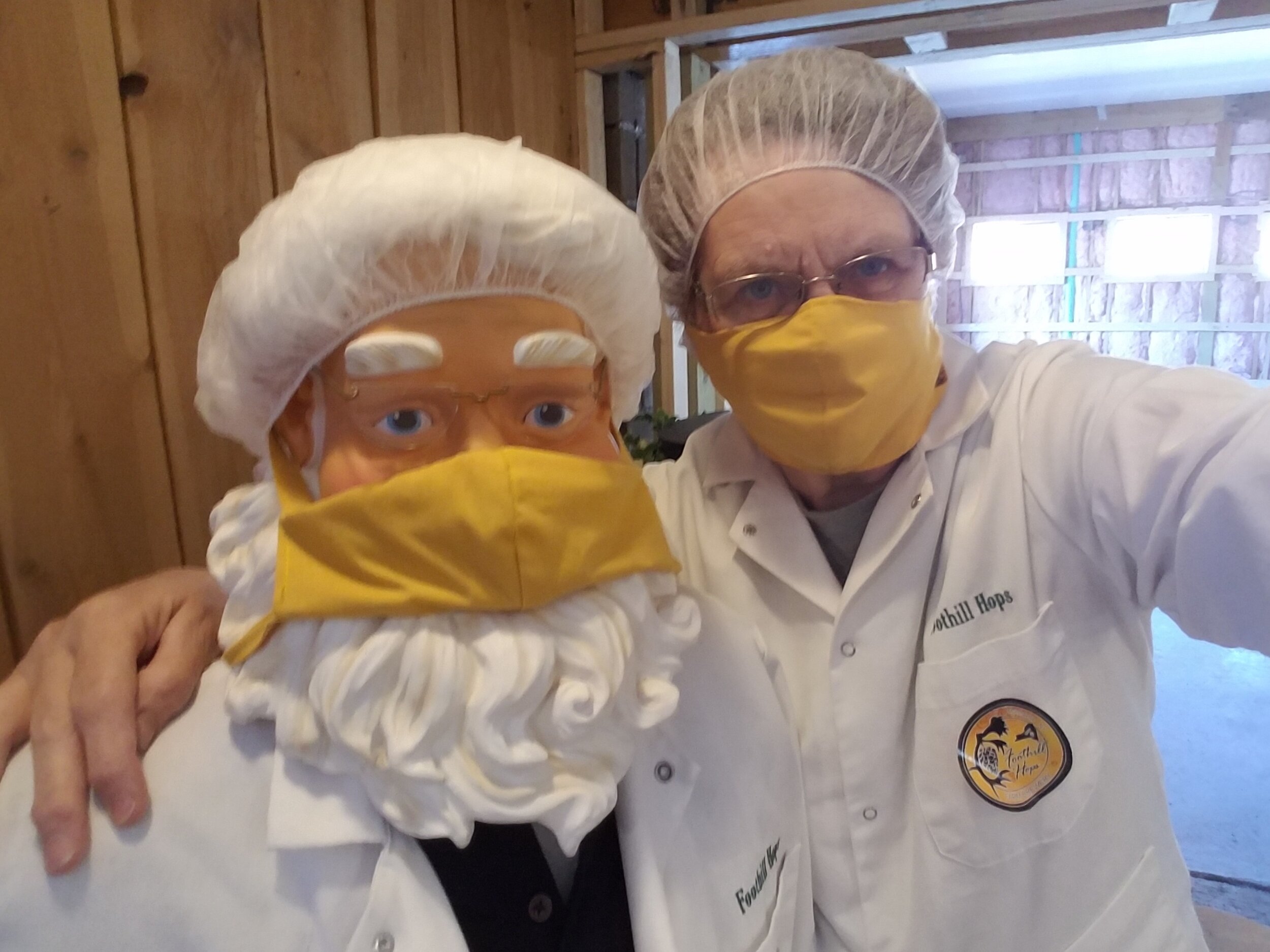 Animated Santa figure and female brewery owner wearing facemask, hairnet and chef's coats.