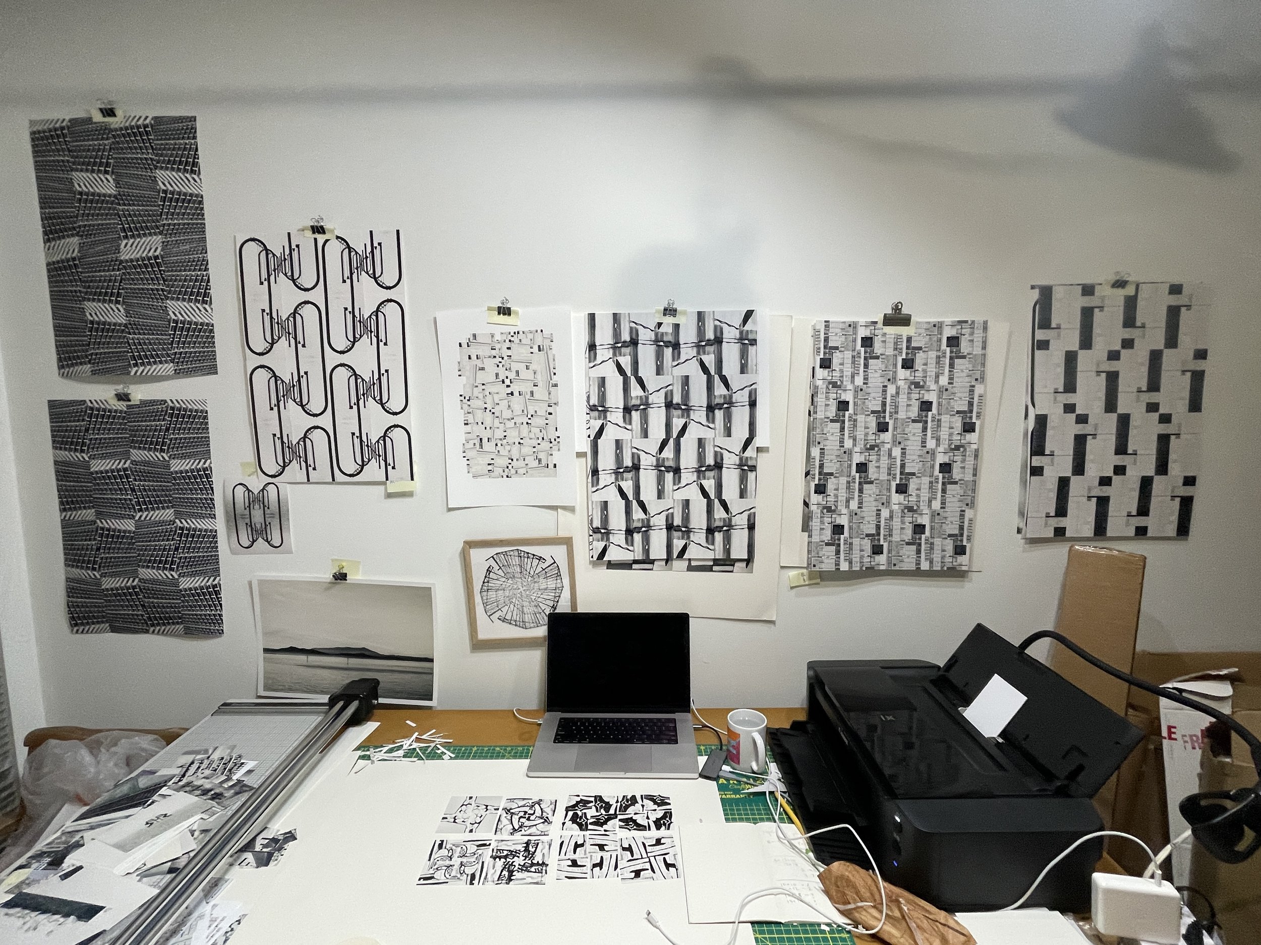 prints hanging on a wall in an art studio