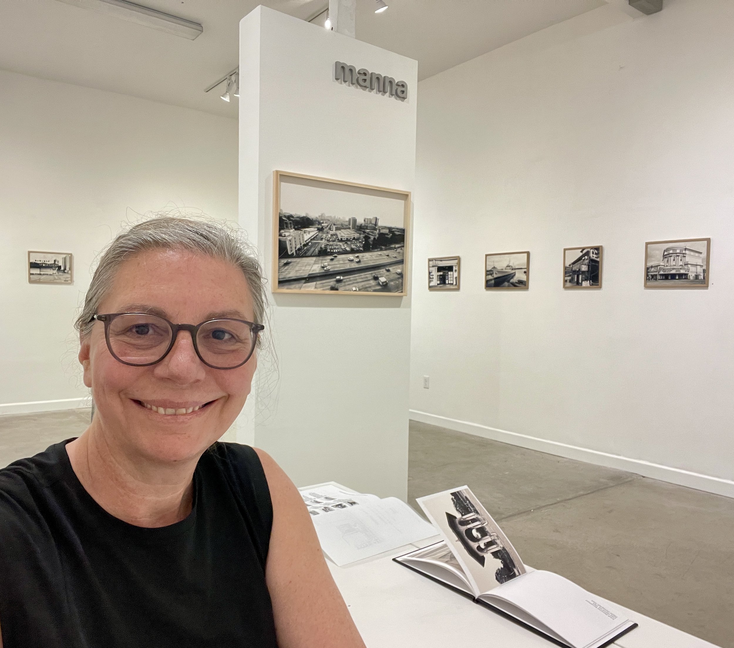 Gina Gaiser at Manna Art Gallery with a black and white photo exhibit.