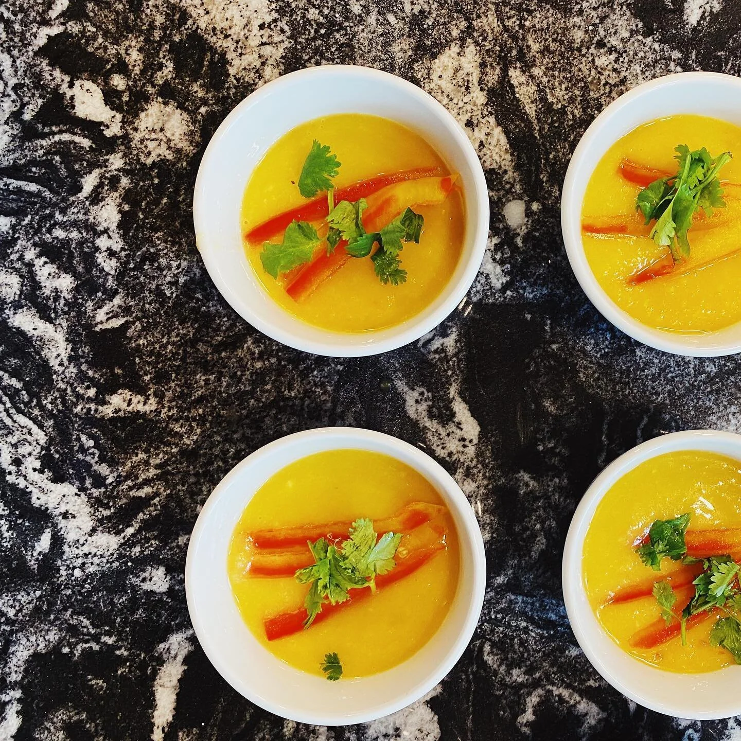 Welcoming peach season with a savory peach gazpacho with a striped pepper and cilantro garnish 🍑