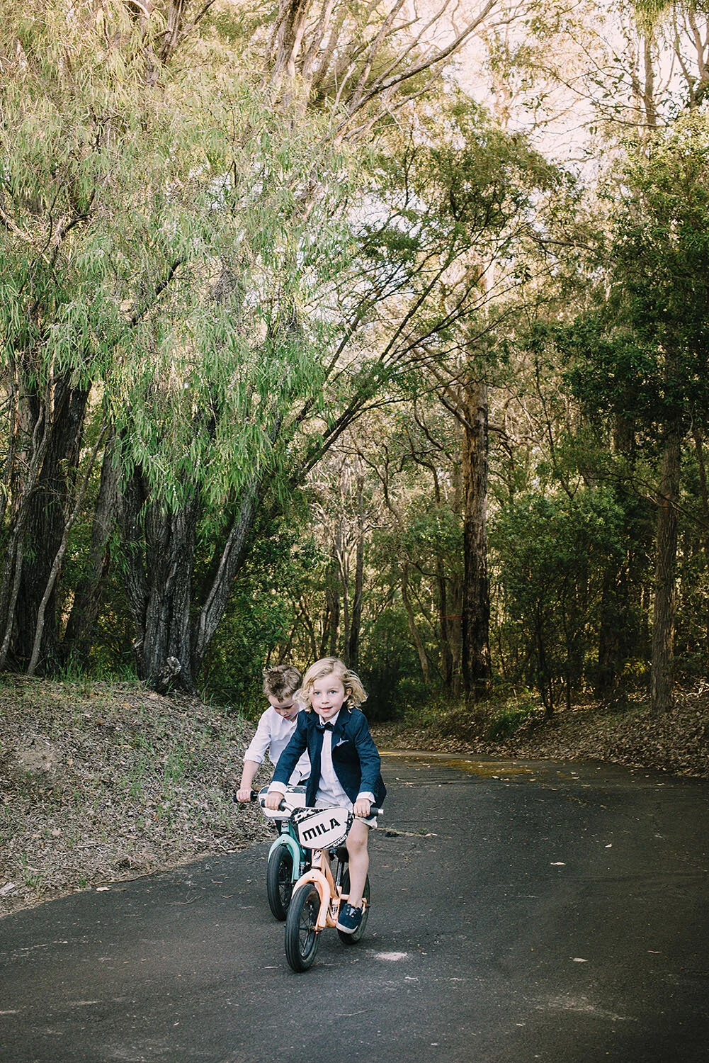 two page boys ride their push bikes at elopement.jpg