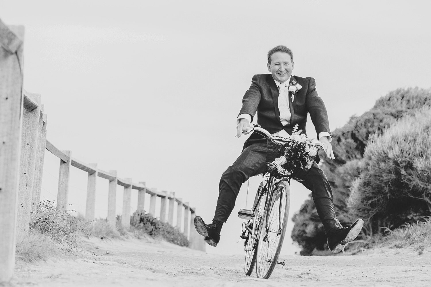Groom laughing riding bicycle Fremantle Wedding Photograph.jpg