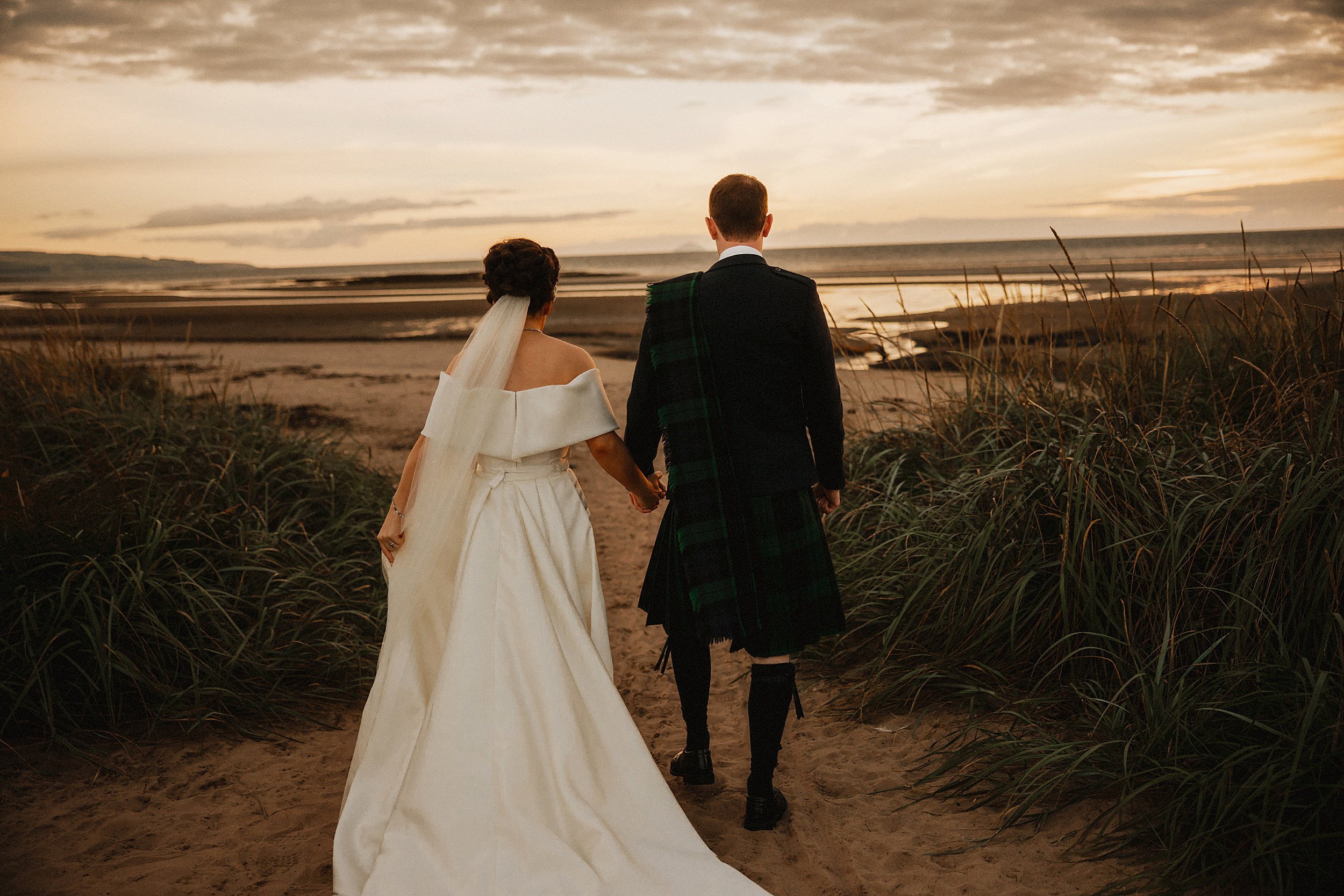 Wedding couple walk on beach at Lochgreen House Hotel