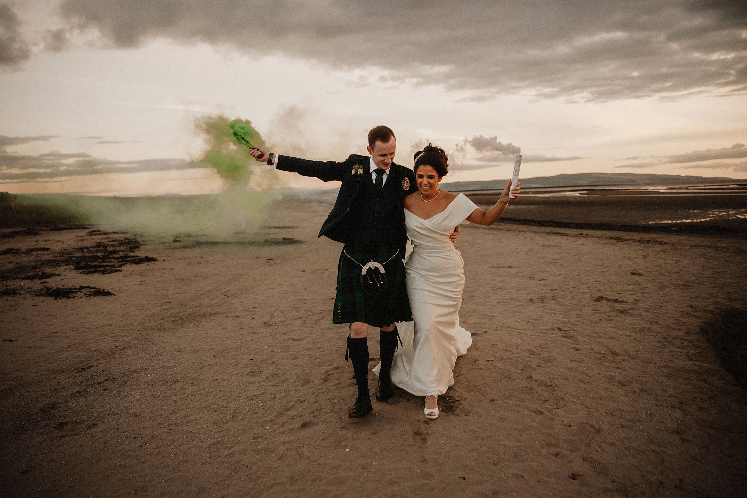 Bride and groom walking with smoke bombs at beach for Lochgreen House Hotel wedding