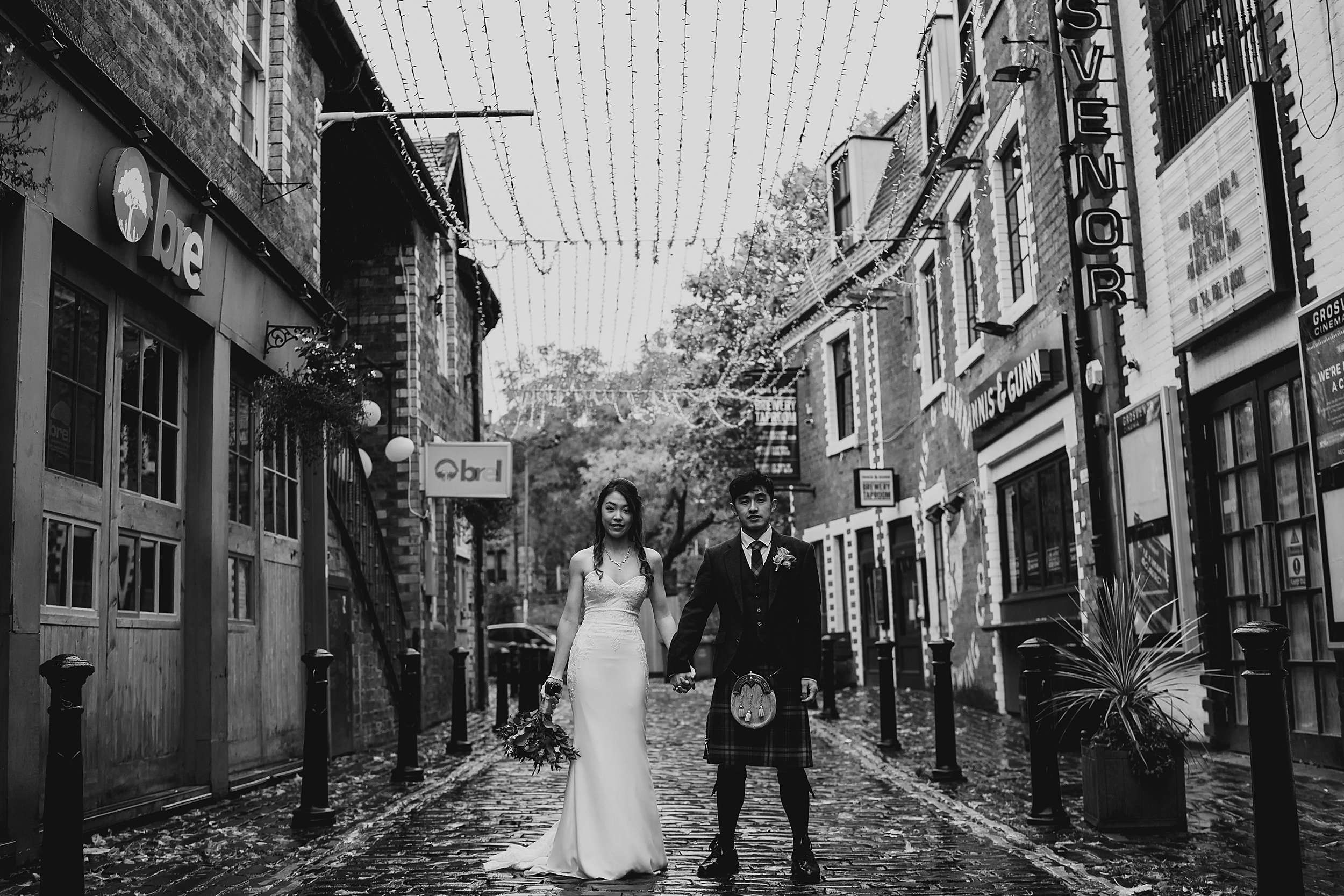 wedding couple standing in Ashton Lane Glasgow before their Chinese Scottish wedding at The Bothy