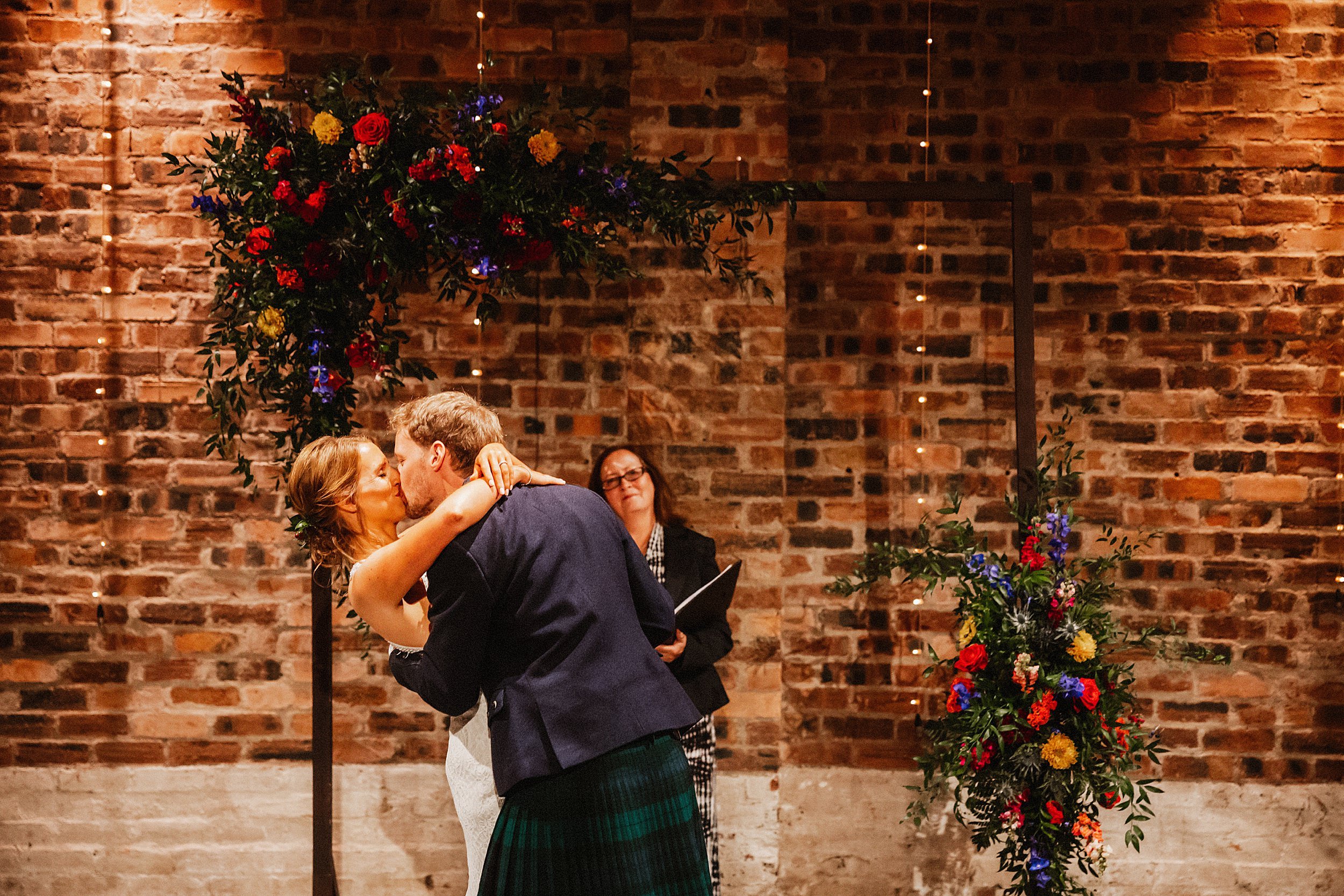 Bride and groom's first kiss in the tattie barn at Kinkell Byre St Andrews wedding