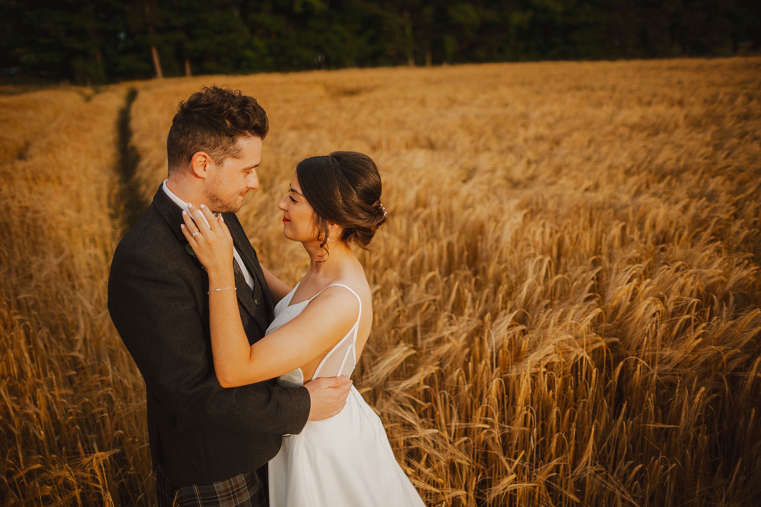 Wedding couple share a moment in a wheat field at Enterkine House Hotel on their wedding day