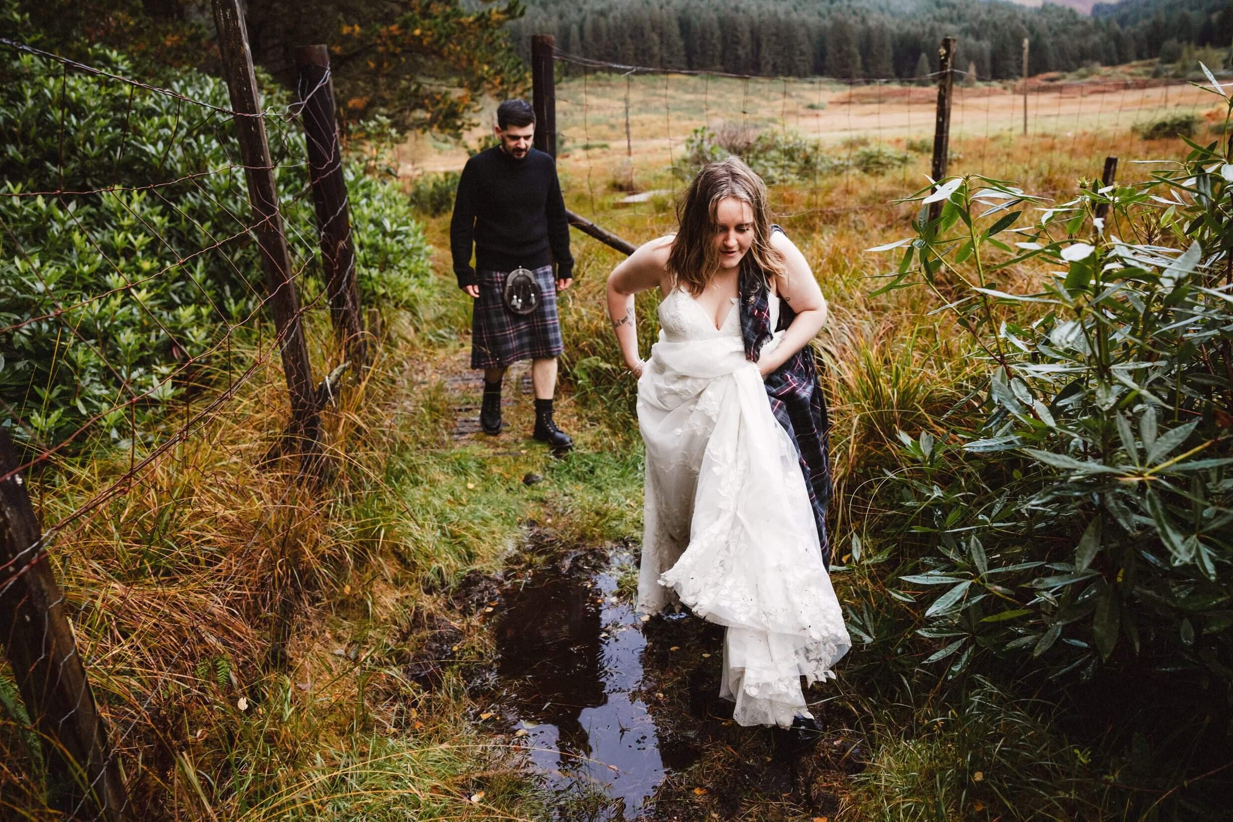 bride jumps over a puddle during scottish outdoor glencoe elopement