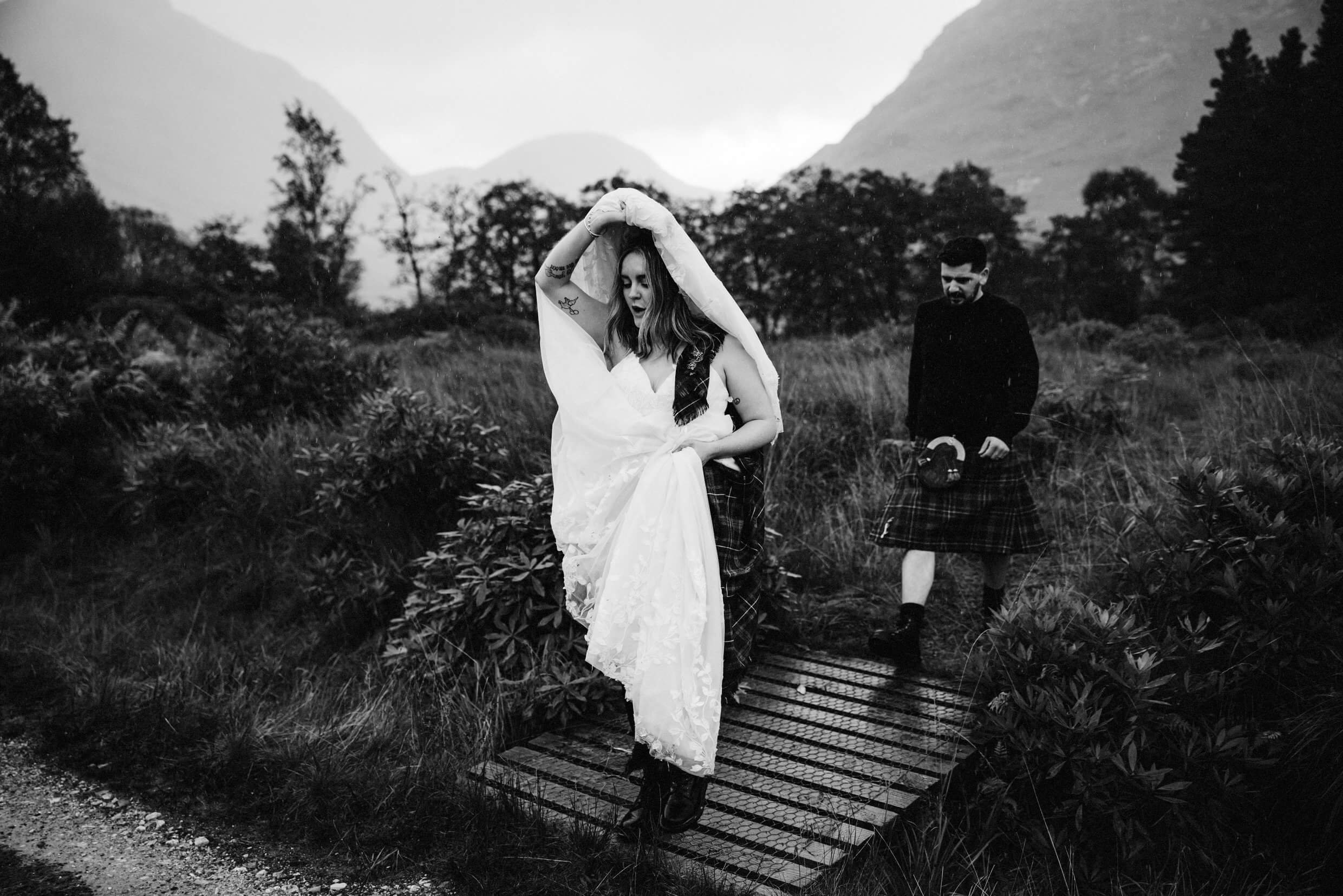 bride uses dress as shelter during scottish glencoe elopement in glen etive scotland
