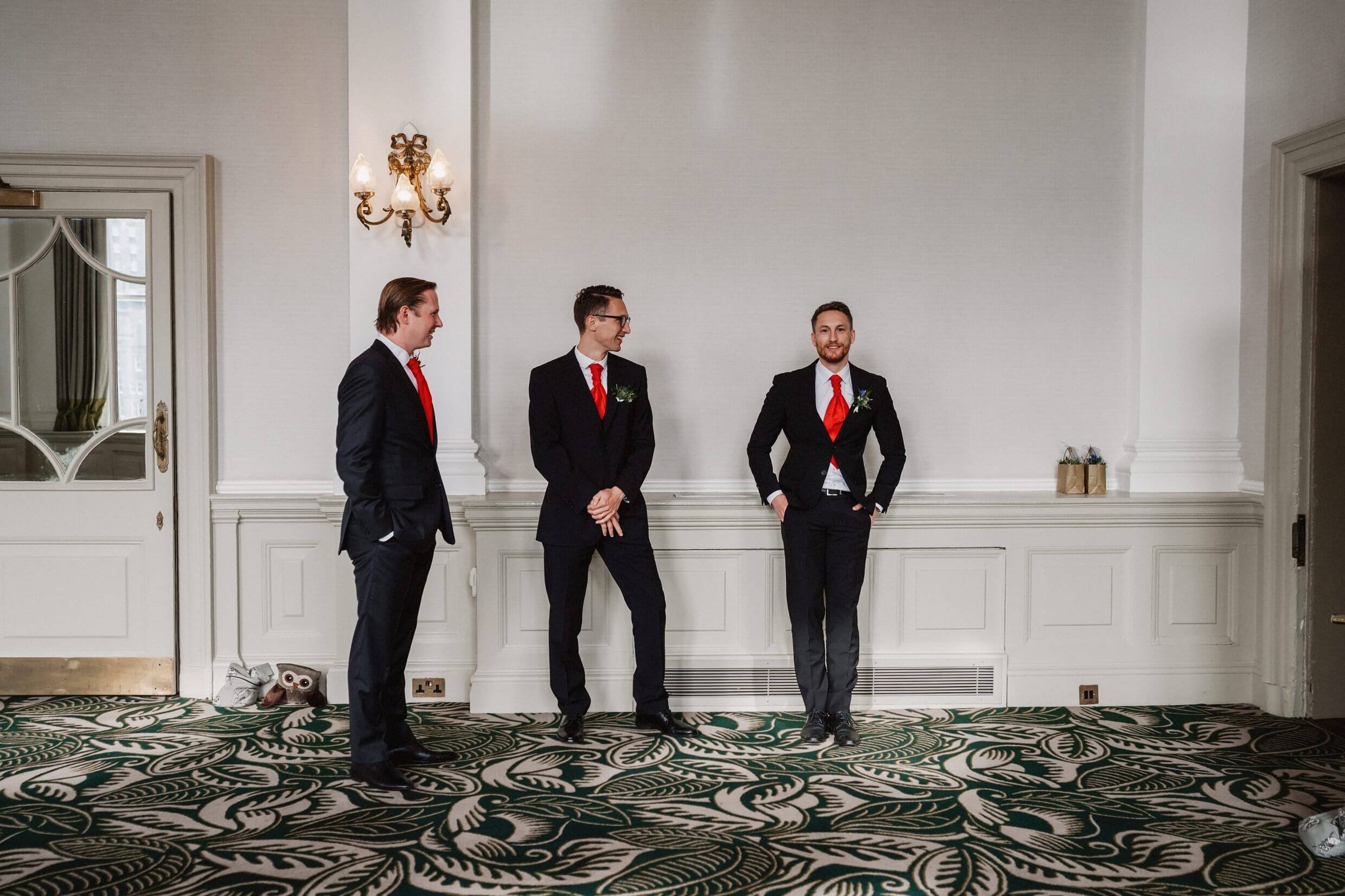 inside interior view of the balmoral hotel edinburgh wedding venue in scotland showing three groomsmen waiting before the ceremony begins