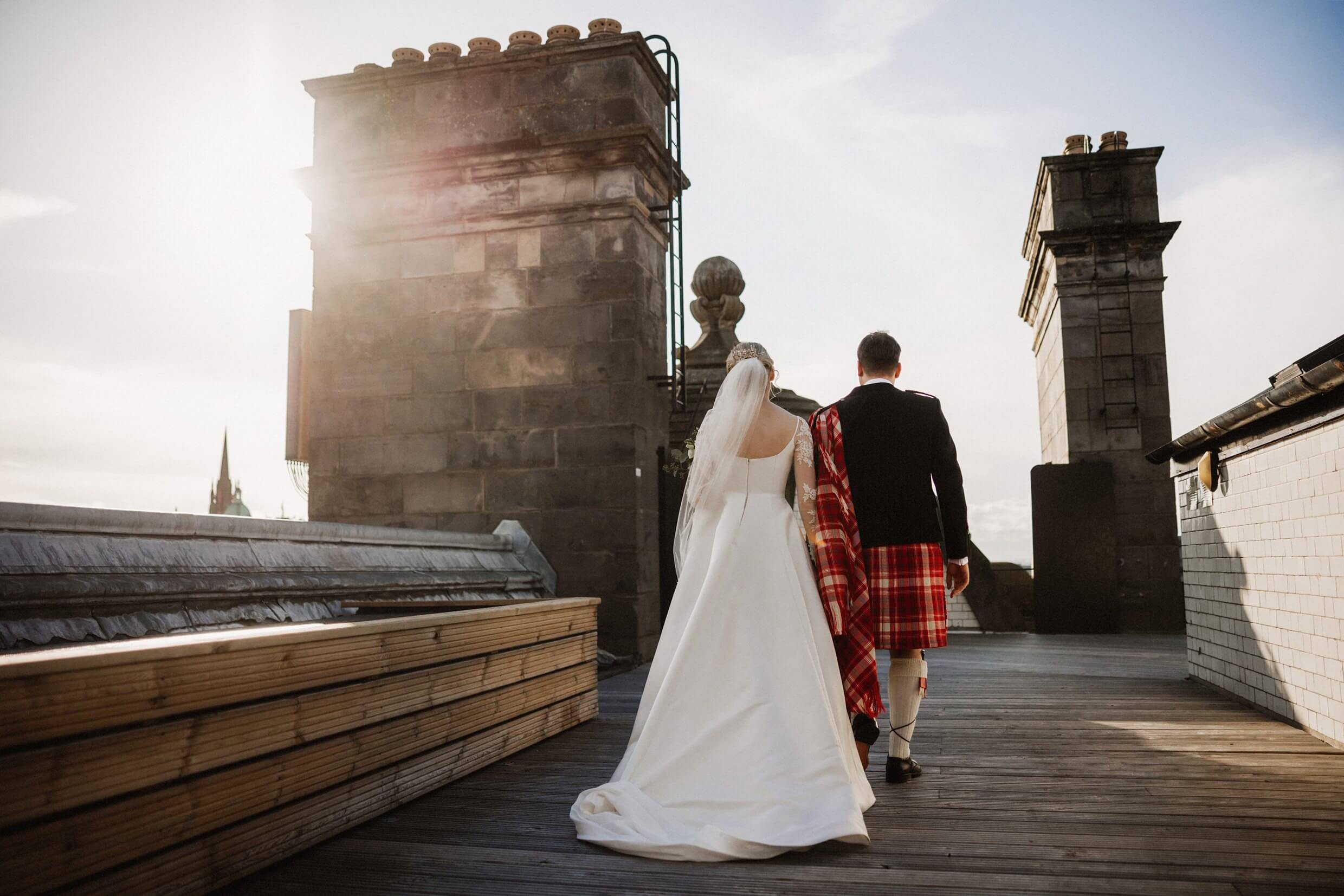 the bride and groom on the roof of the balmoral hotel following their edinburgh wedding ceremony