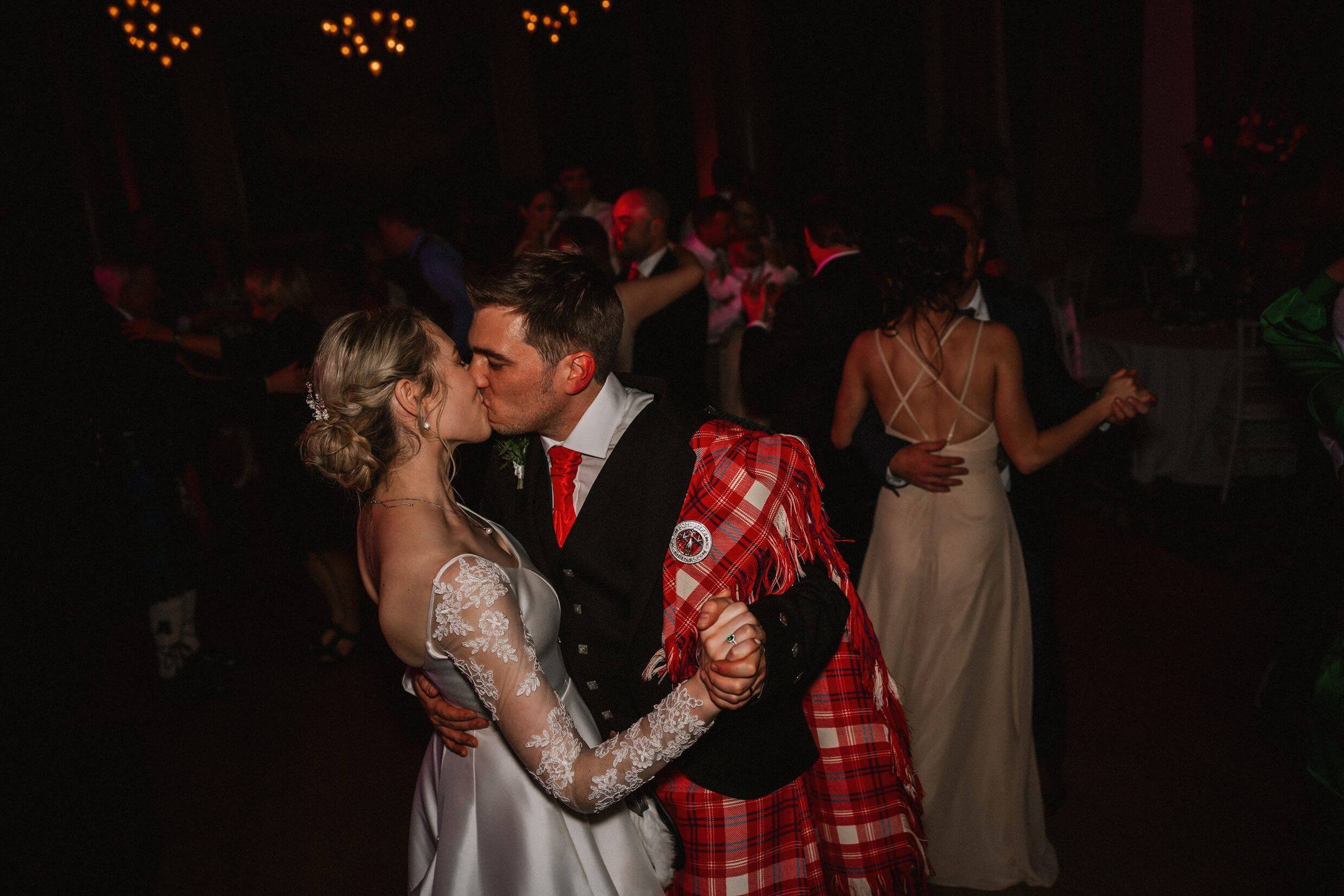 the bride and groom kiss as they dance at their evening reception at the balmoral hotel edinburgh wedding venue in scotland
