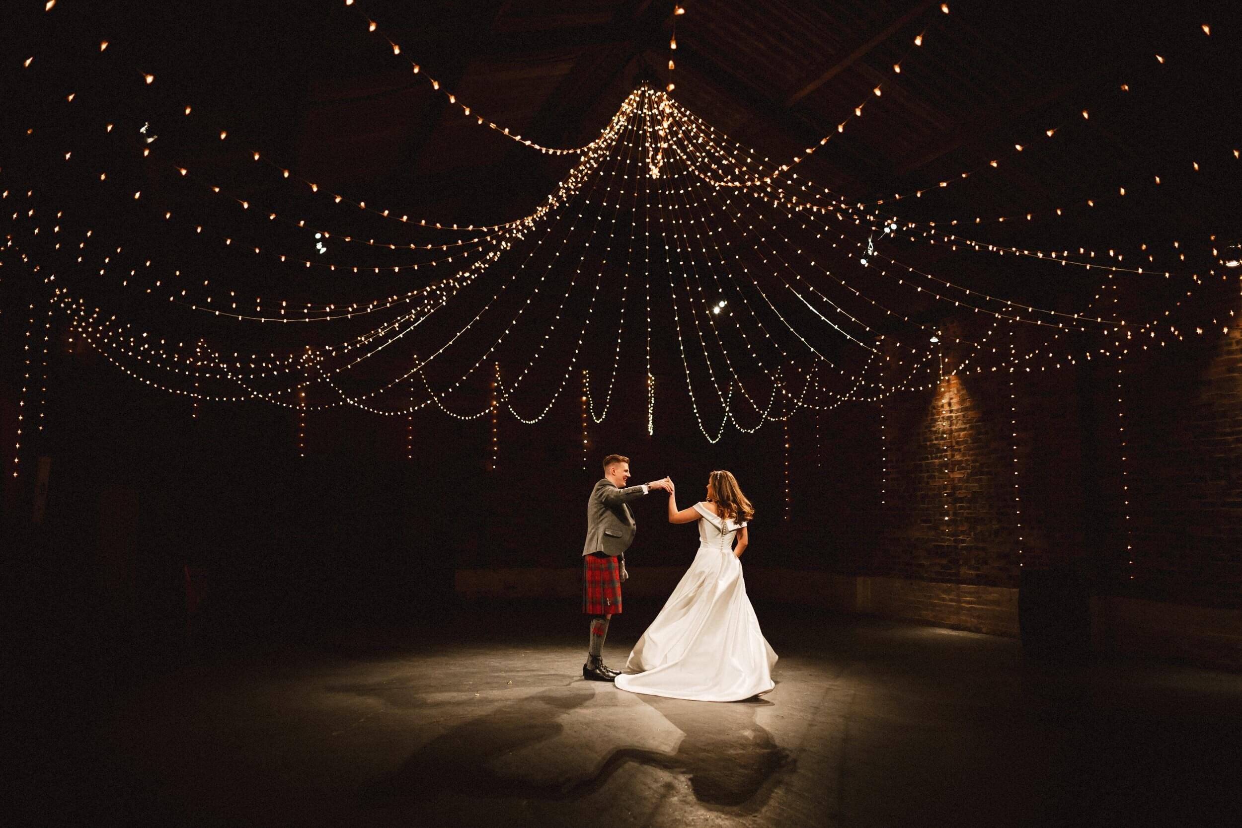 glasgow wedding photographer captures the bride and groom's first dance beneath festoon lighting