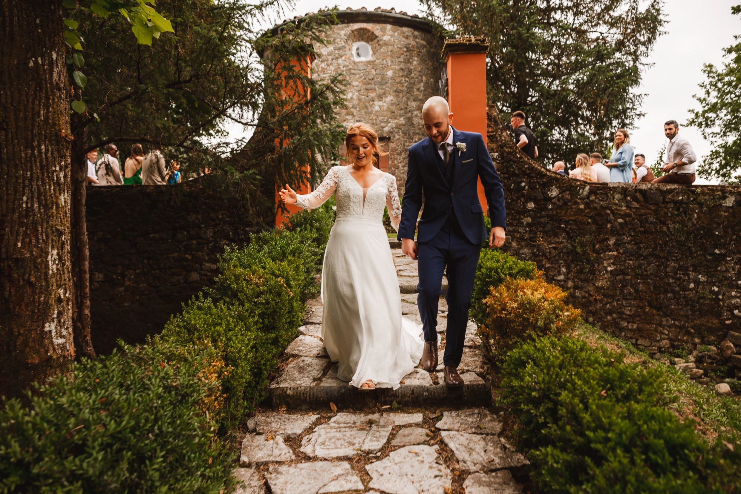 the bride and groom leaving the private chapel following their wedding ceremony at the agriturismo la torre italian destination wedding venue in bagni di lucca tuscany