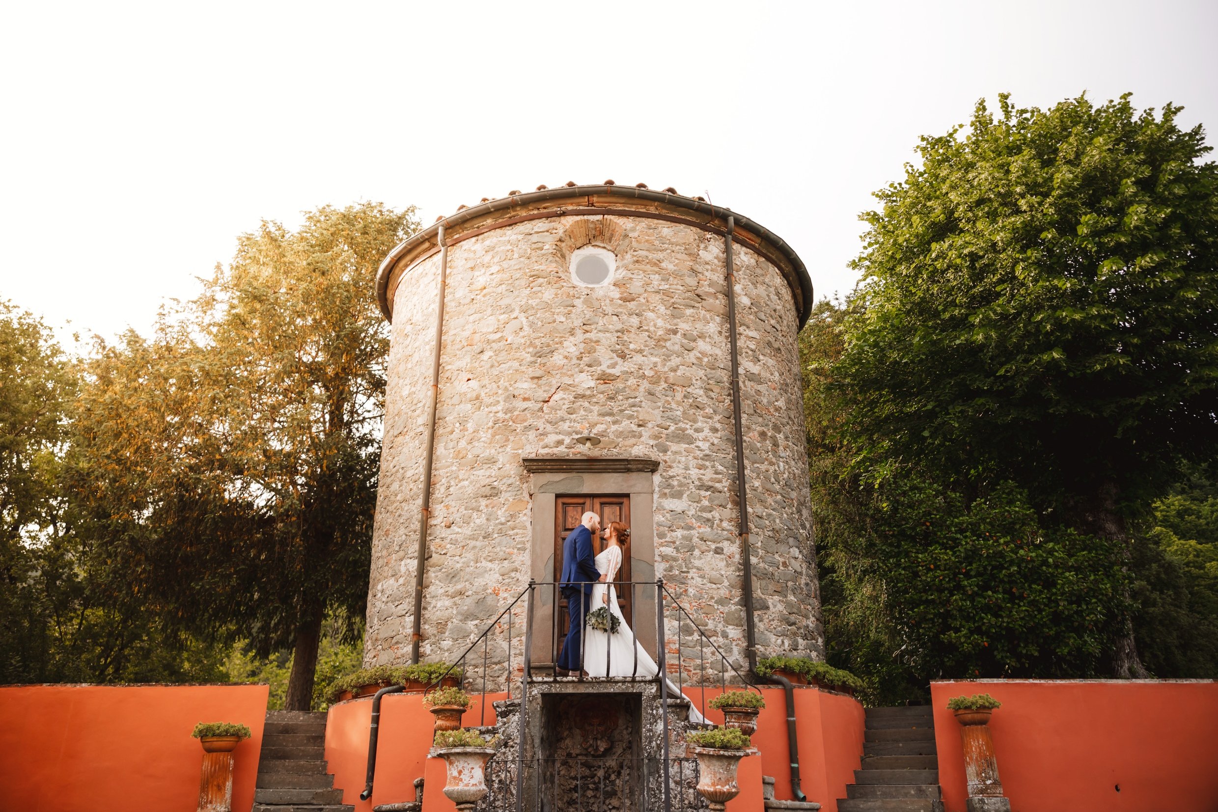 the bride and groom standing in front of the private chapel at the agriturismo la torre italian destination wedding venue in bagni di lucca tuscany