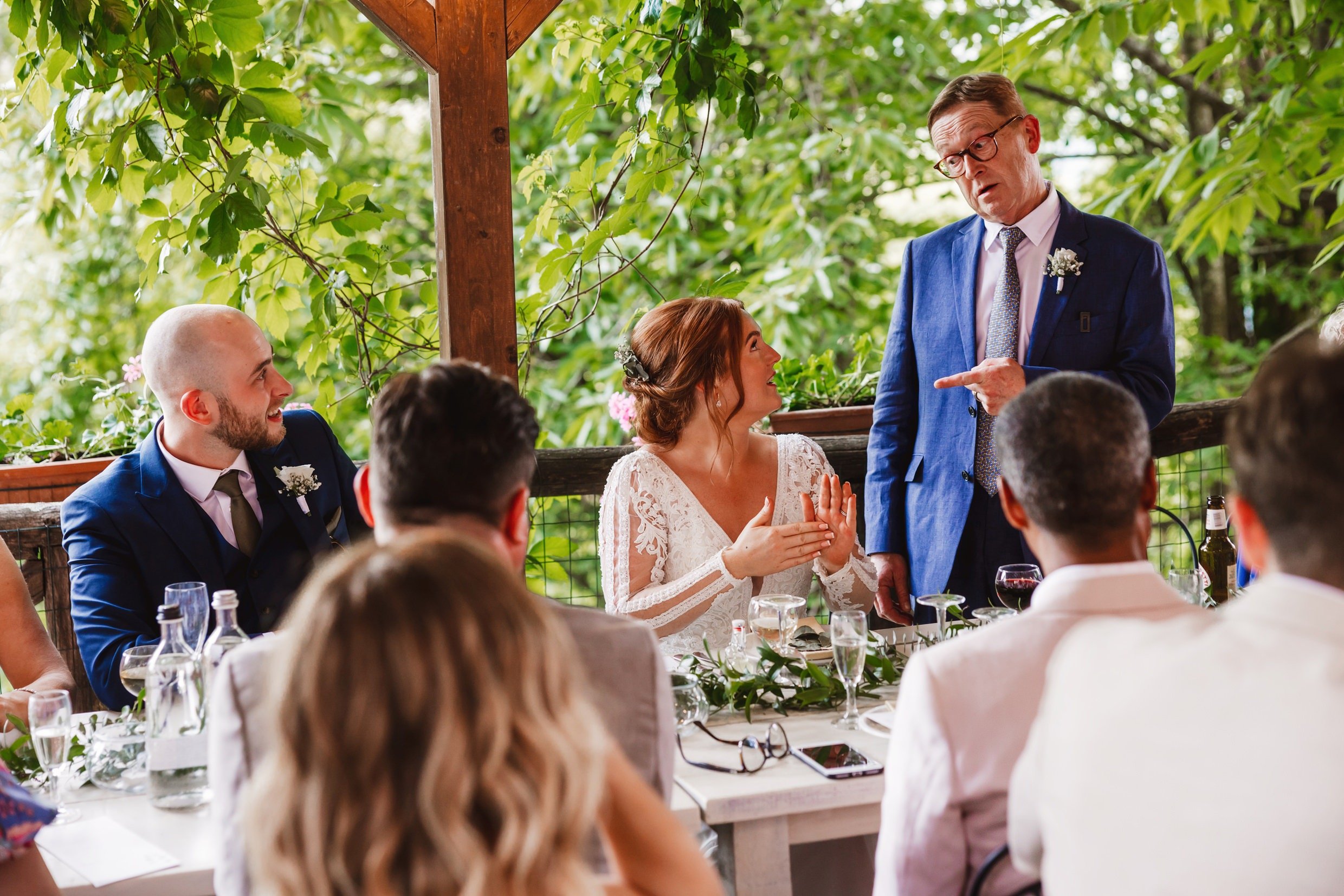 the father of the bride gives his speech at the wedding reception at the agriturismo la torre italian destination wedding venue in bagni di lucca tuscany