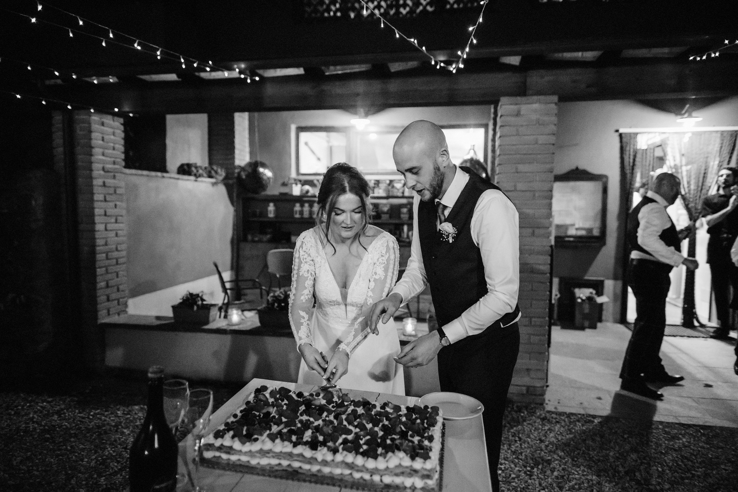 the bride and groom cut their wedding cake at the agriturismo la torre italian destination wedding venue in bagni di lucca tuscany