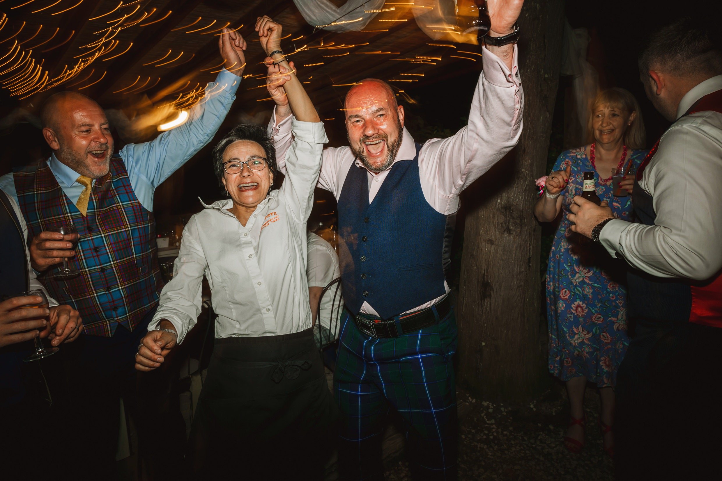 wedding guests dancing outside at the agriturismo la torre italian destination wedding venue in bagni di lucca tuscany