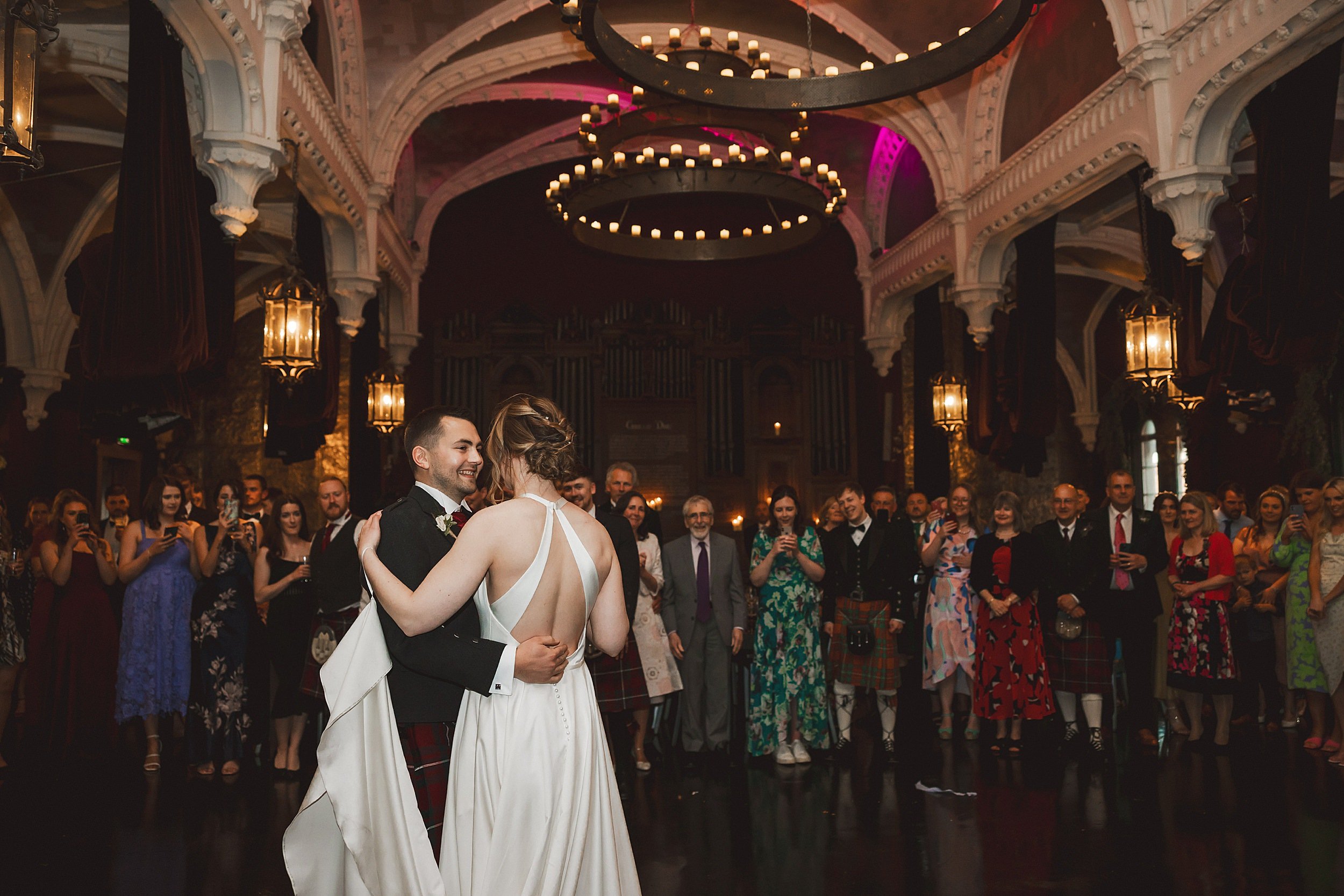 the bride and grooms first dance underneath chandeliers in the auditorium at the ghillie dhu edinburgh wedding venue by documentary wedding photographer edinburgh