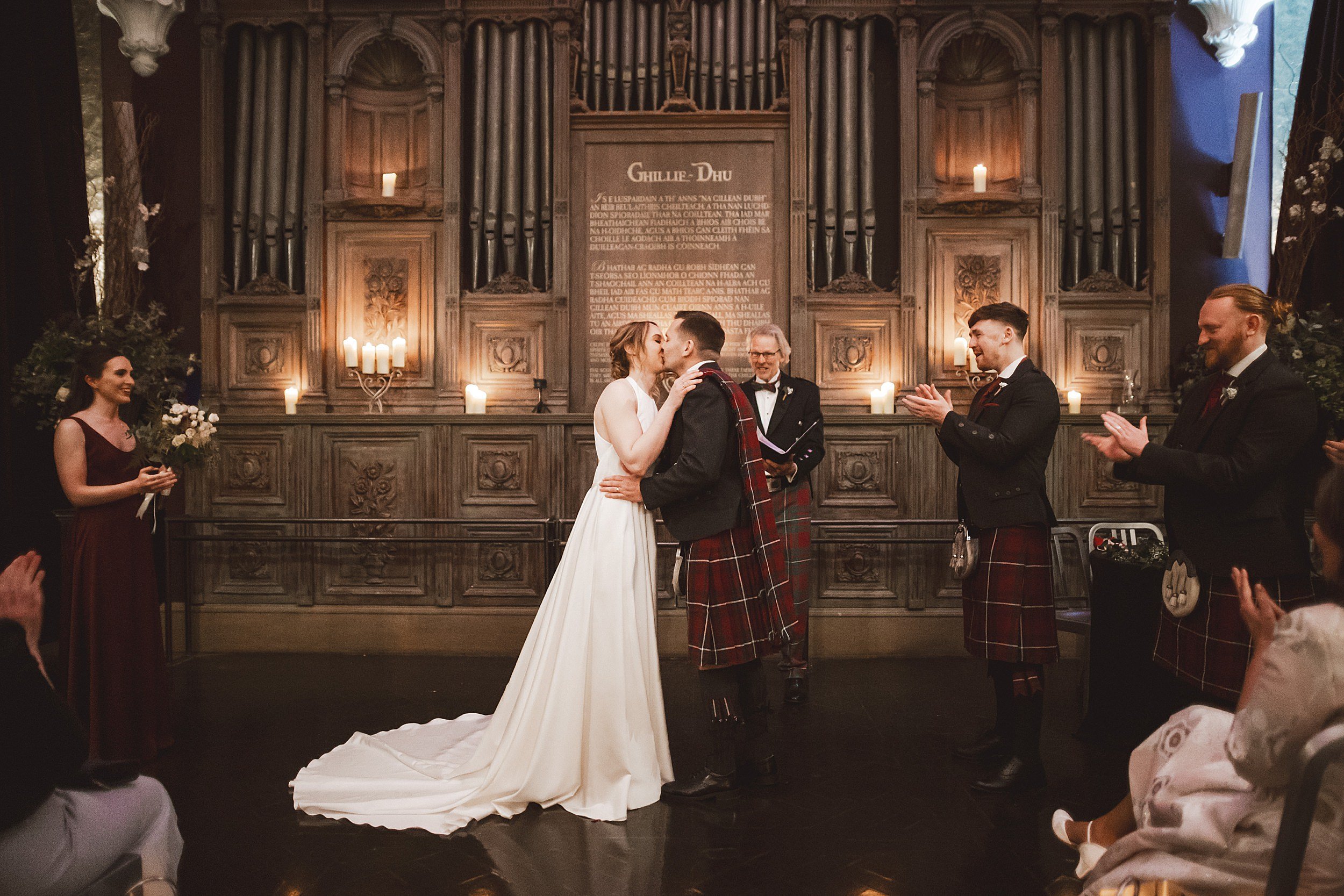 the bride and groom kiss during their wedding ceremony at unique wedding venue the ghillie dhu in scotland shot by documentary wedding photographer edinburgh