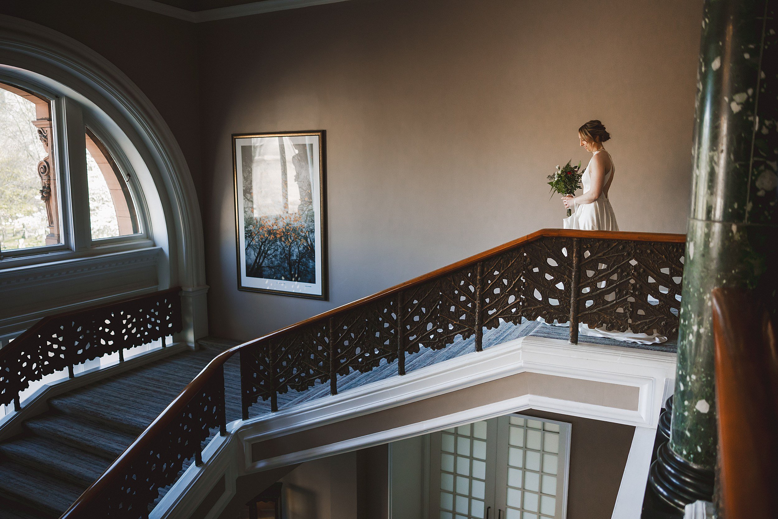 the bride descending a staircase at the caledonian waldorf astoria hotel shot by documentary wedding photographer edinburgh scotland