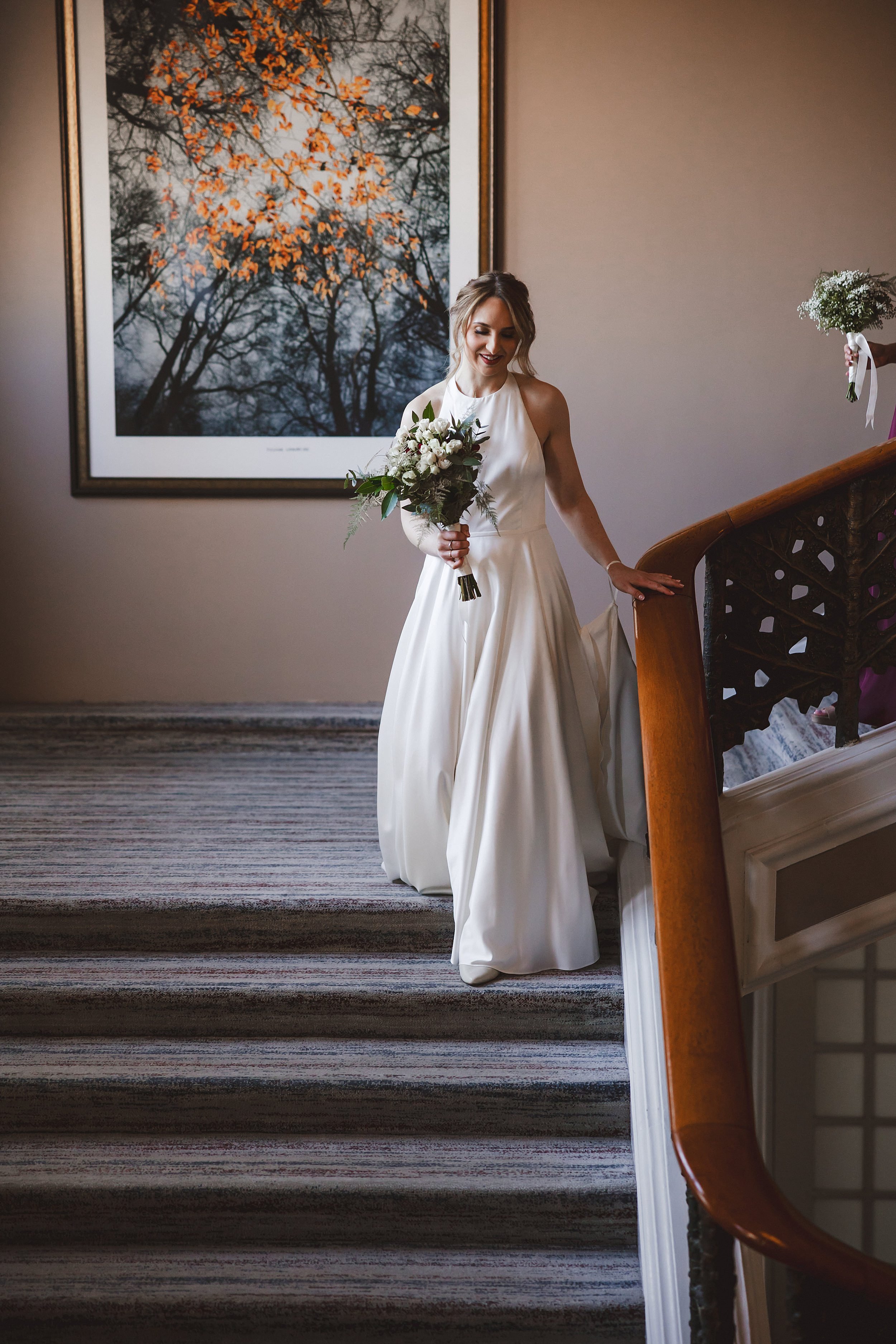 the bride descending a staircase at the caledonian waldorf astoria hotel shot by documentary wedding photographer edinburgh scotland