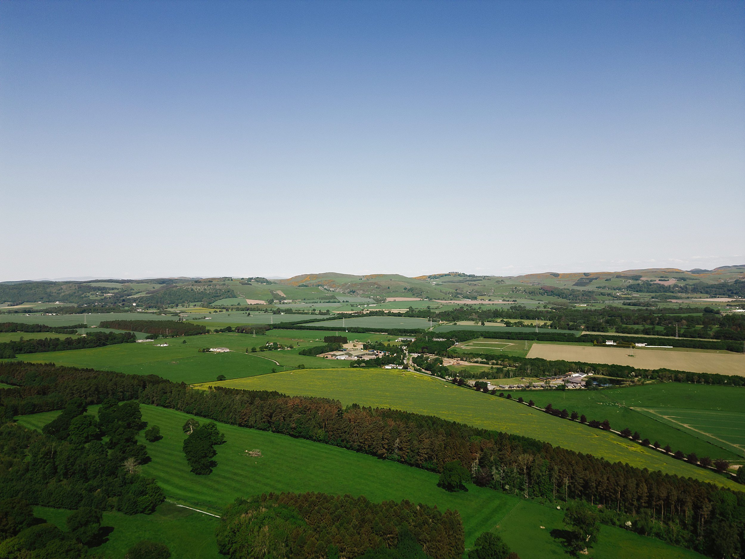 outside aerial view of the countryside surrounding errol park wedding venue in perthshire scotland green fields trees and hills are visible