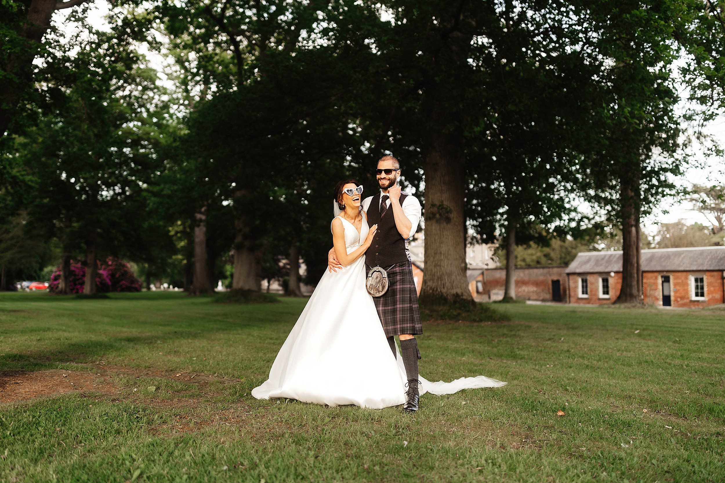 the bride and groom pose wearing sunglasses in the gardens of errol park wedding venue in perthsire in scotland