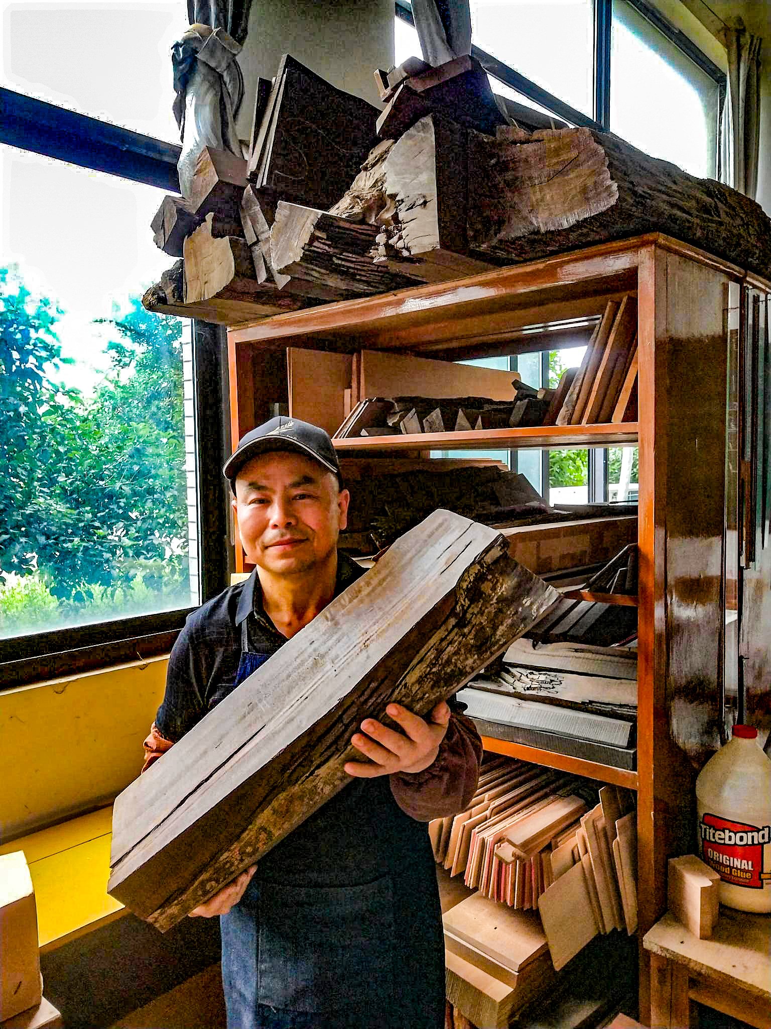 Dejawu Guitars - WU Dongming holding a piece of 7500-year-old sinker wood.