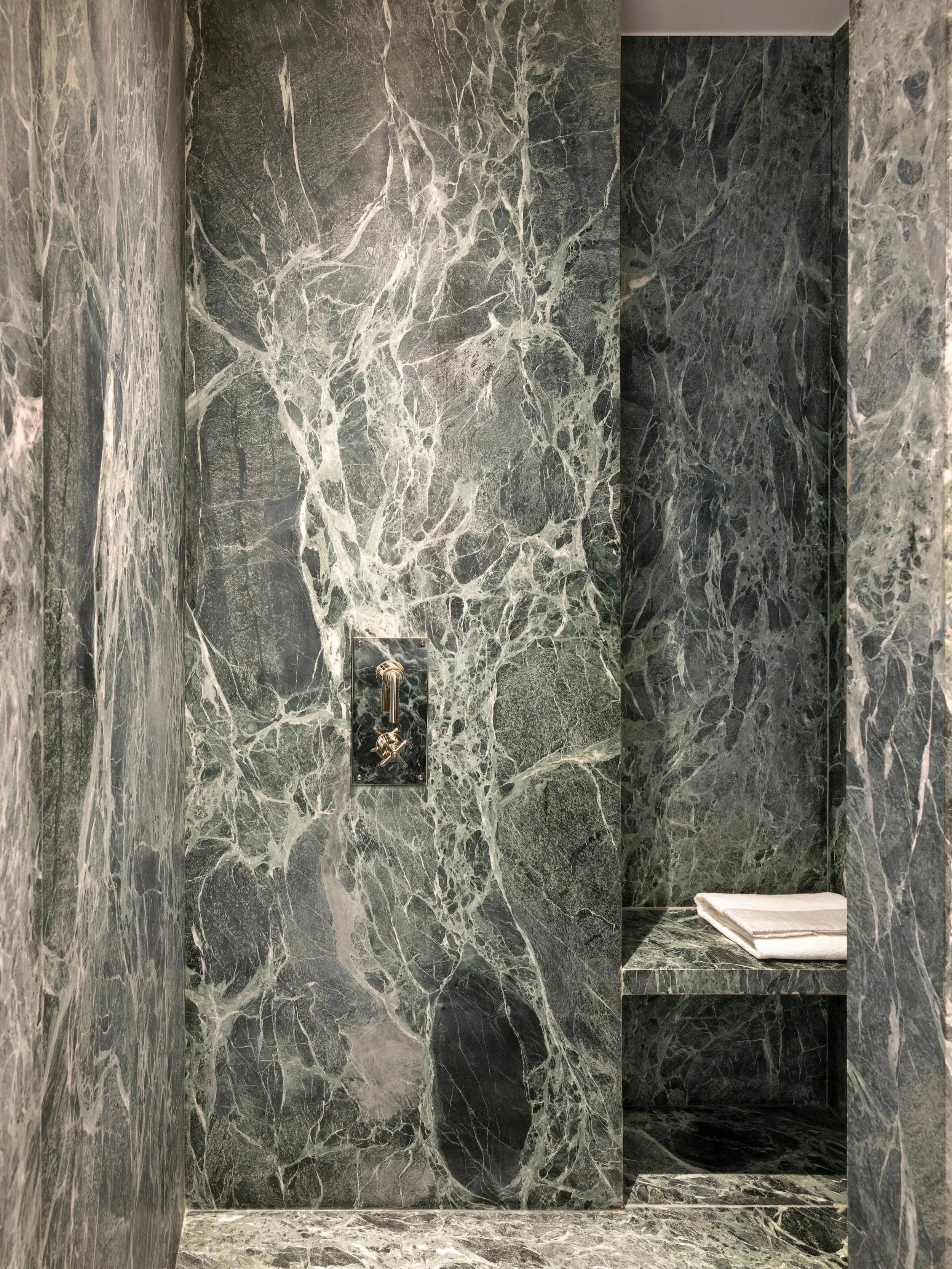 Marbre vert profond, travertin, laiton. Une salle de bain qui n&rsquo;a rien a envier
aux plus grands hotels.
Architecture d&rsquo;interieur : @afterbachstudio | Art &amp; mobilier : @kolkhoze | Photographie : @v.leroux |meuble sur mesure : @vedes_bo
