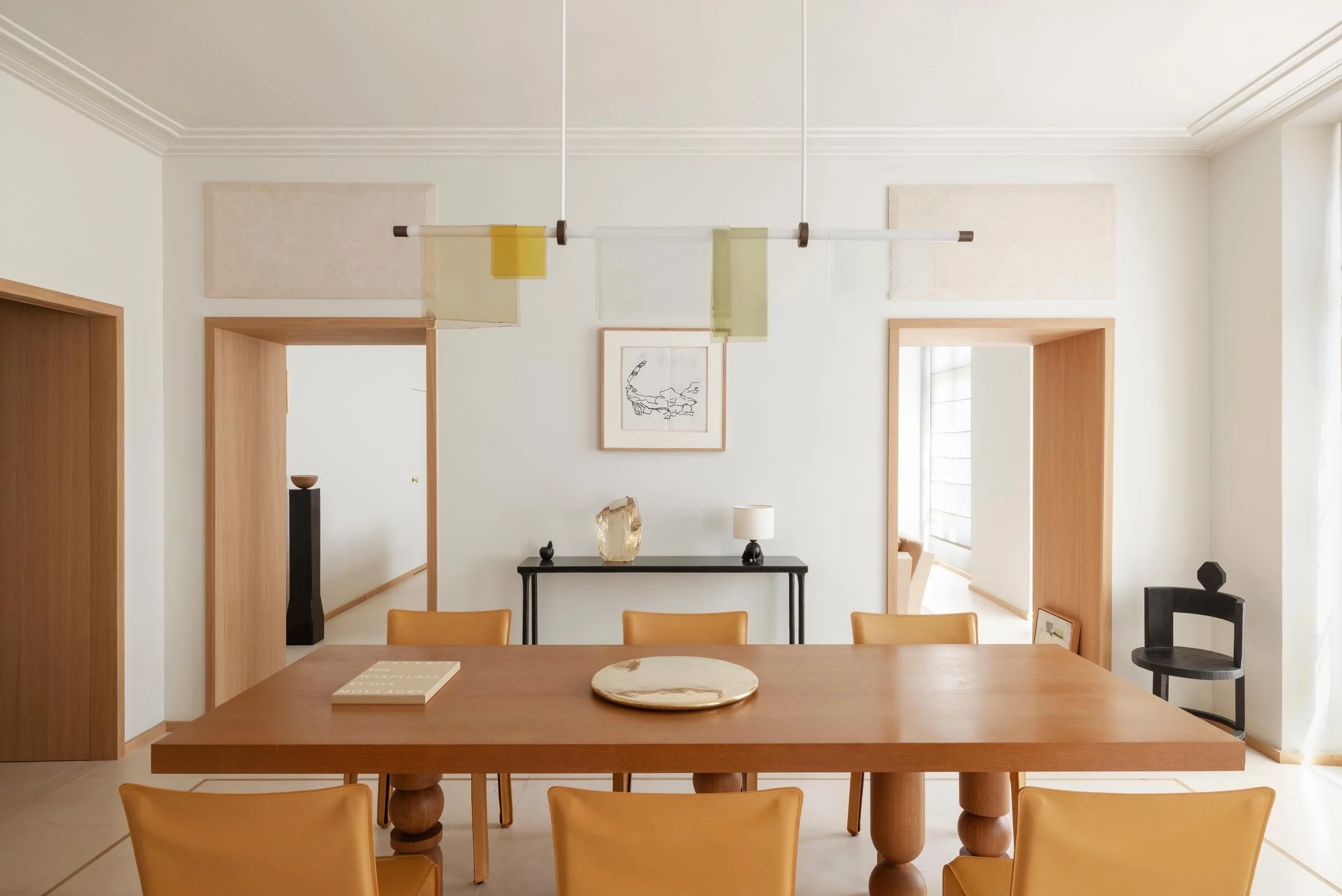 La salle a manger comme un tableau vivant. Lustre suspendu, table en noyer massif,
chaises en cuir &mdash; et des oeuvres qui dialoguent avec chaque matiere.
Architecture d&rsquo;interieur : @afterbachstudio | Art &amp; mobilier : @kolkhoze | Photogr