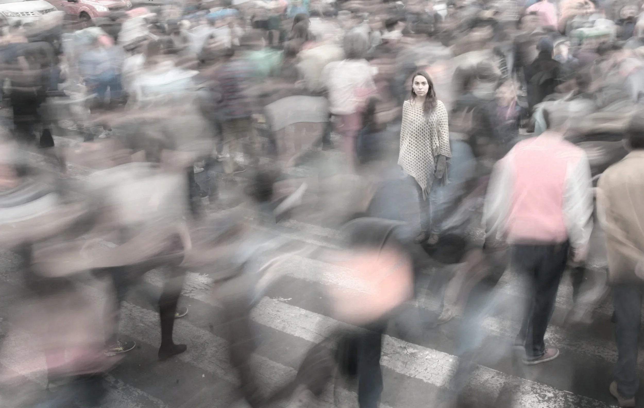 A woman stands motionless in a blurred, rushing crowd, evoking the frozen, unseen experience of an emotional flashback.