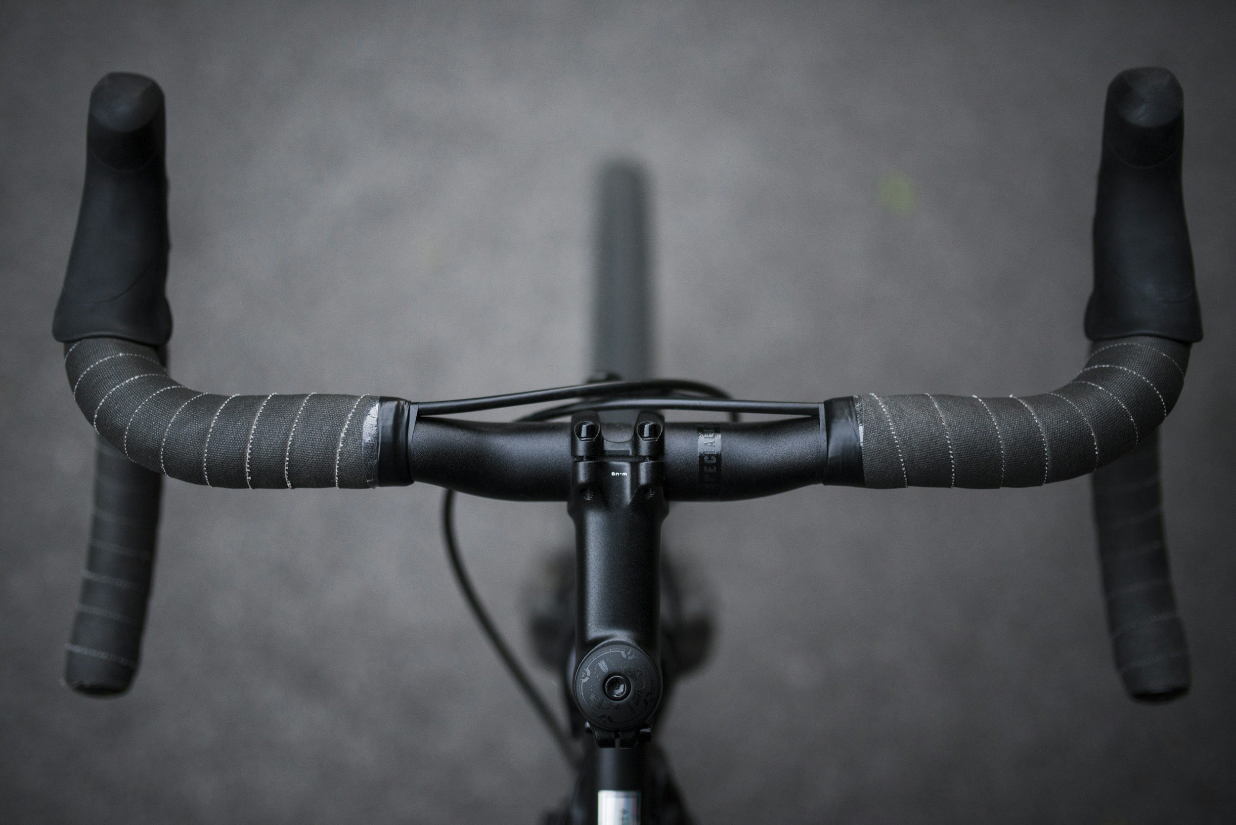 A cyclist's point-of-view looking down at gripped handlebars, representing staying in control throughout an EMDR session.
