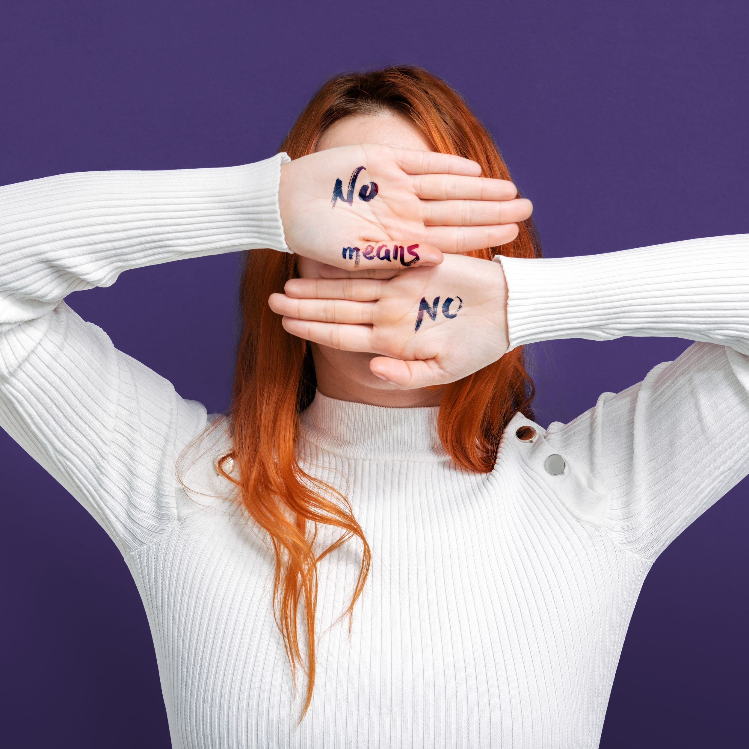 Woman with hands over face written on hands is no means no.jpg