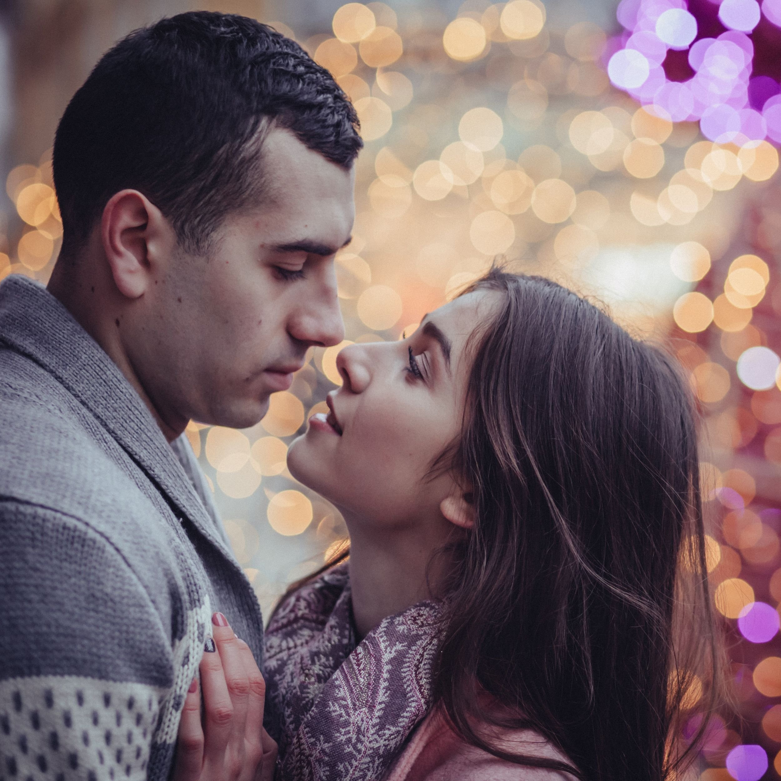 couple looking longingly at one another with twinkly lights in background.jpg