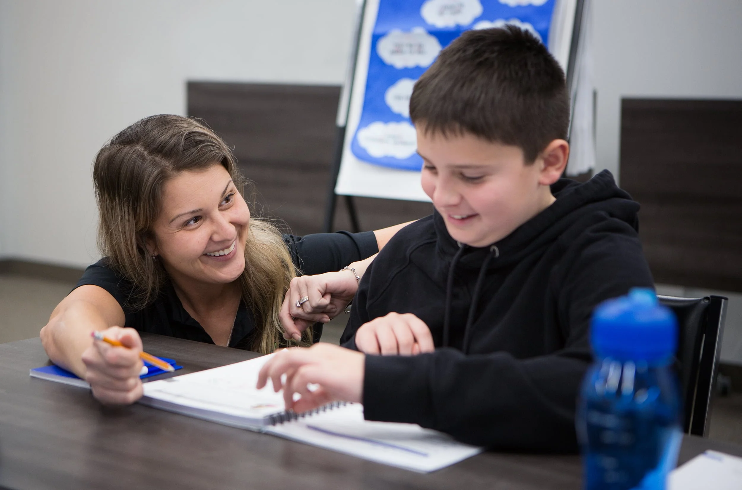 Clinician talking to child looking at workbook.